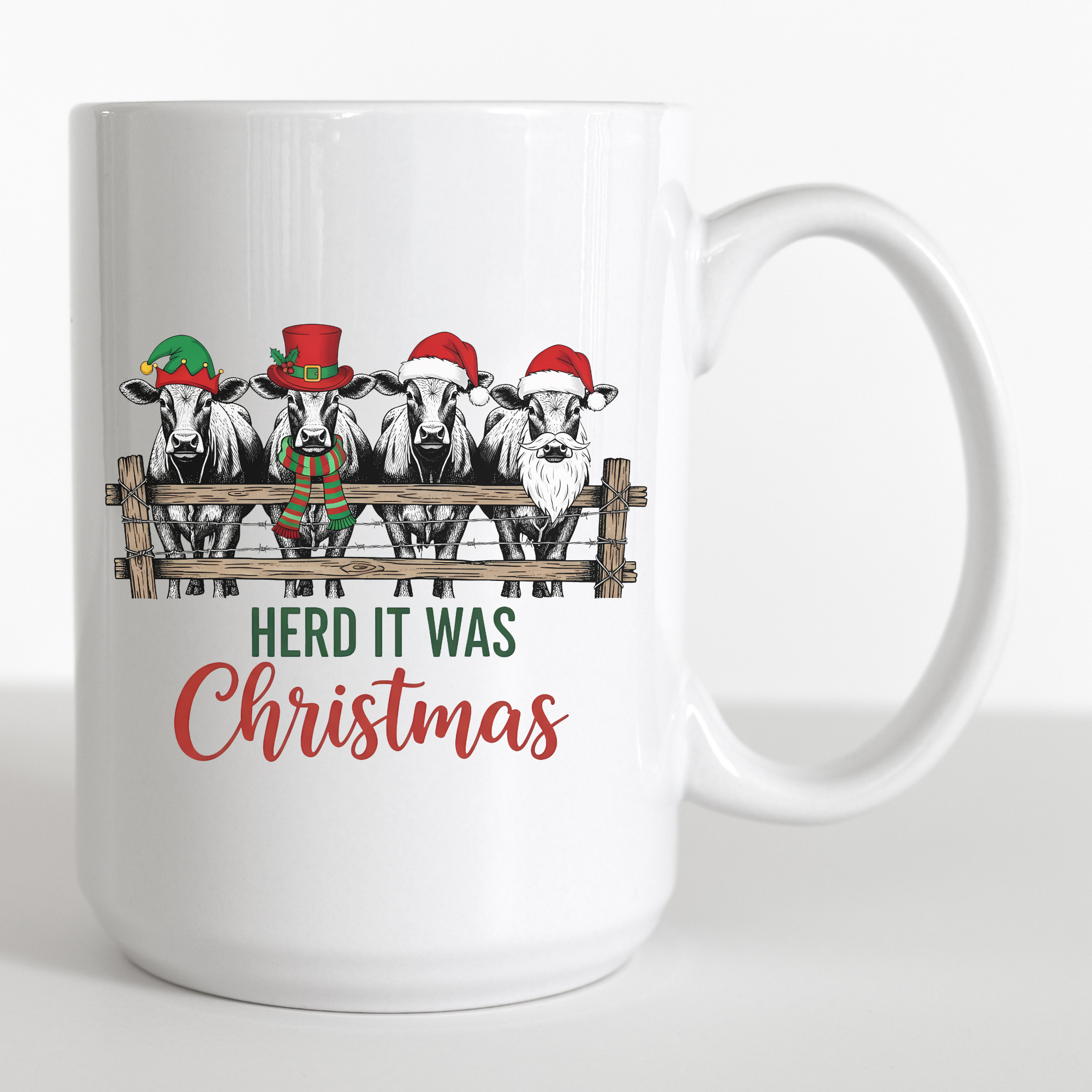 White mug with Christmas-themed design of cows wearing hats and the text 'HERD IT WAS CHRISTMAS' on a white background.