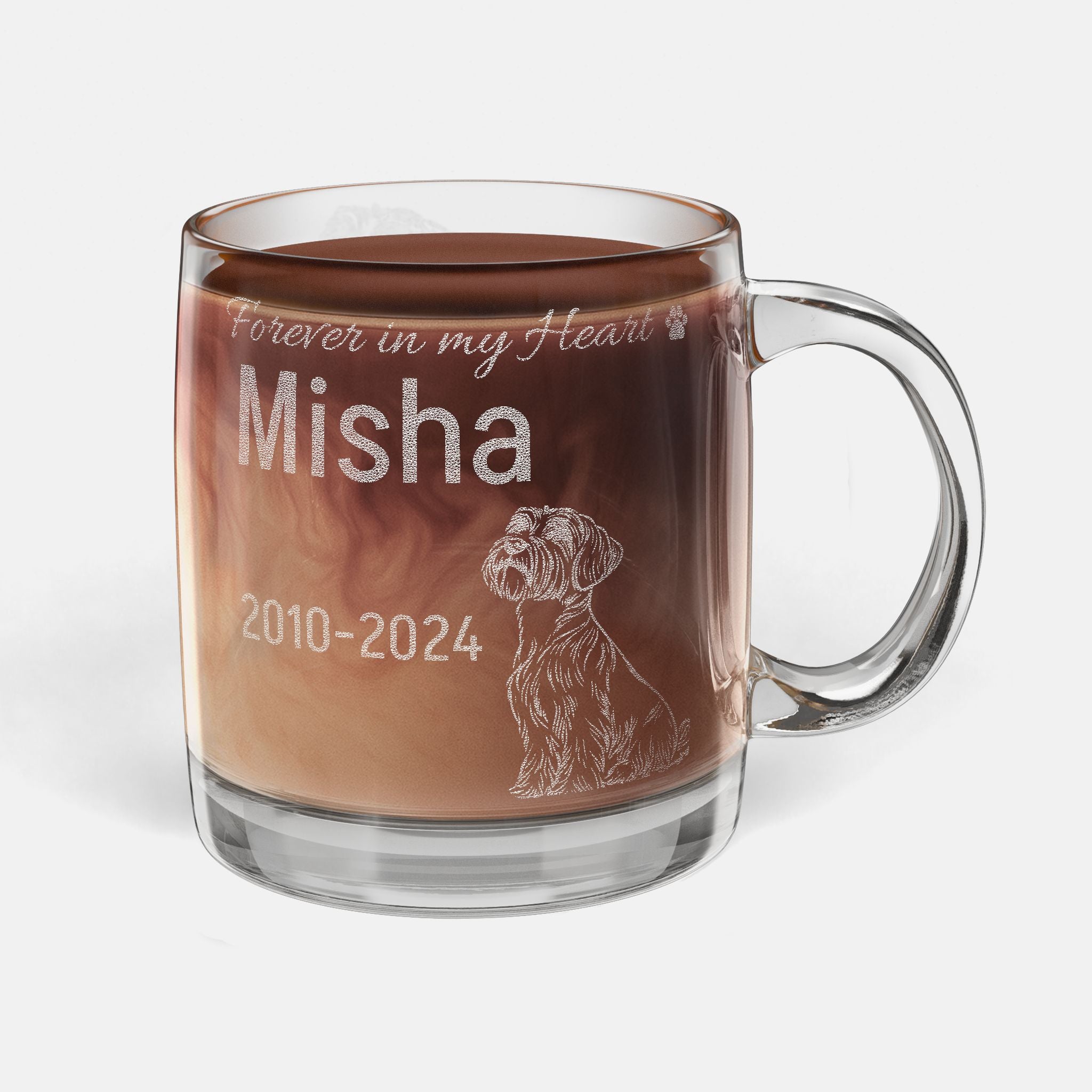 Glass mug with engraved memorial text and a Black Russian Terrier dog illustration, filled with hot chocolate.