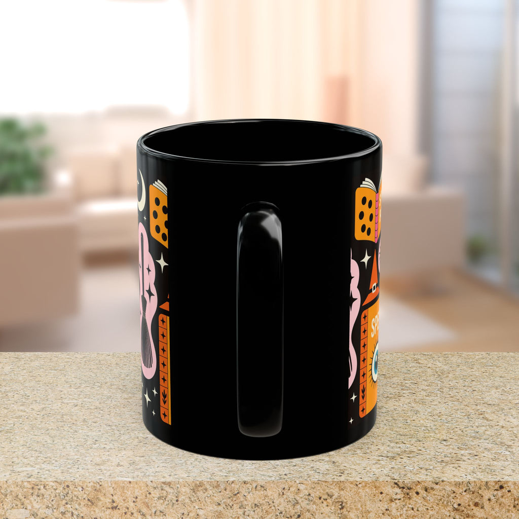 Black mug with colorful designs on a table