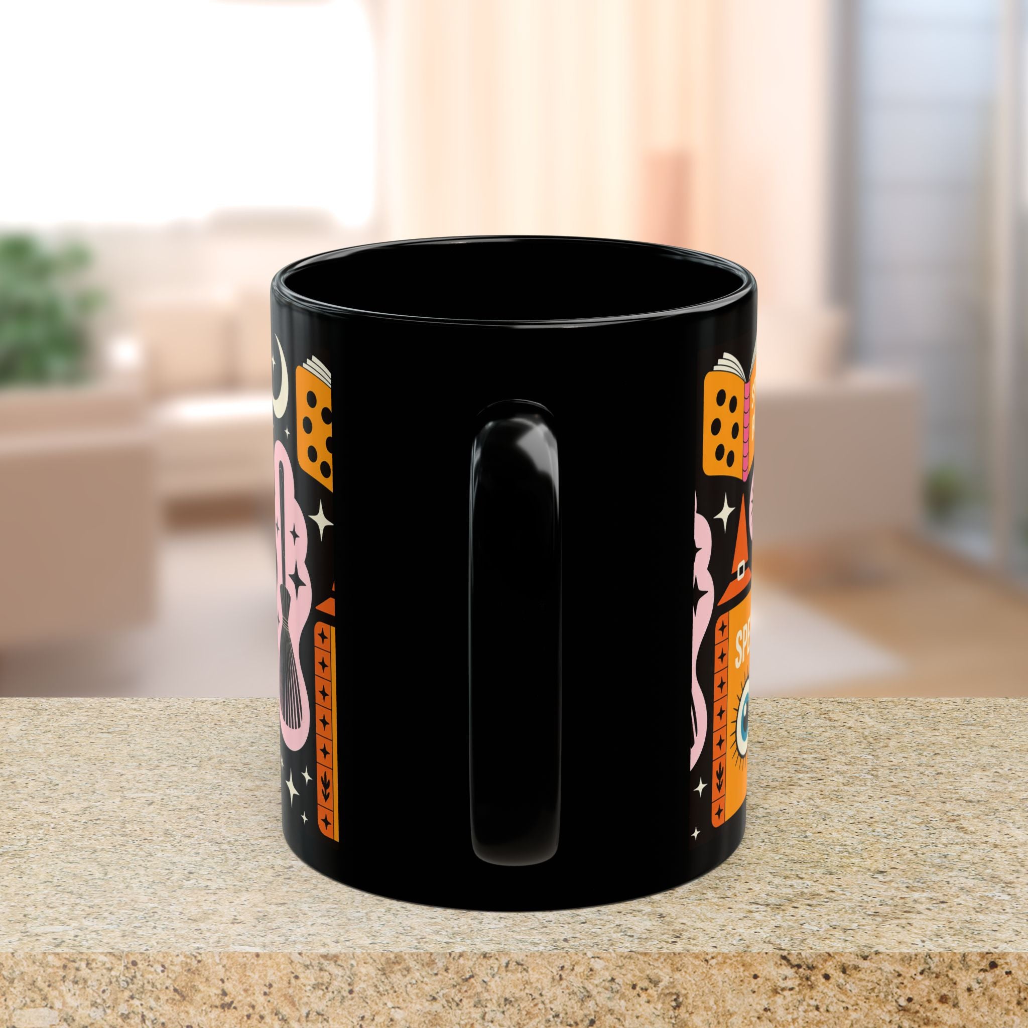 Black mug with colorful designs on a table