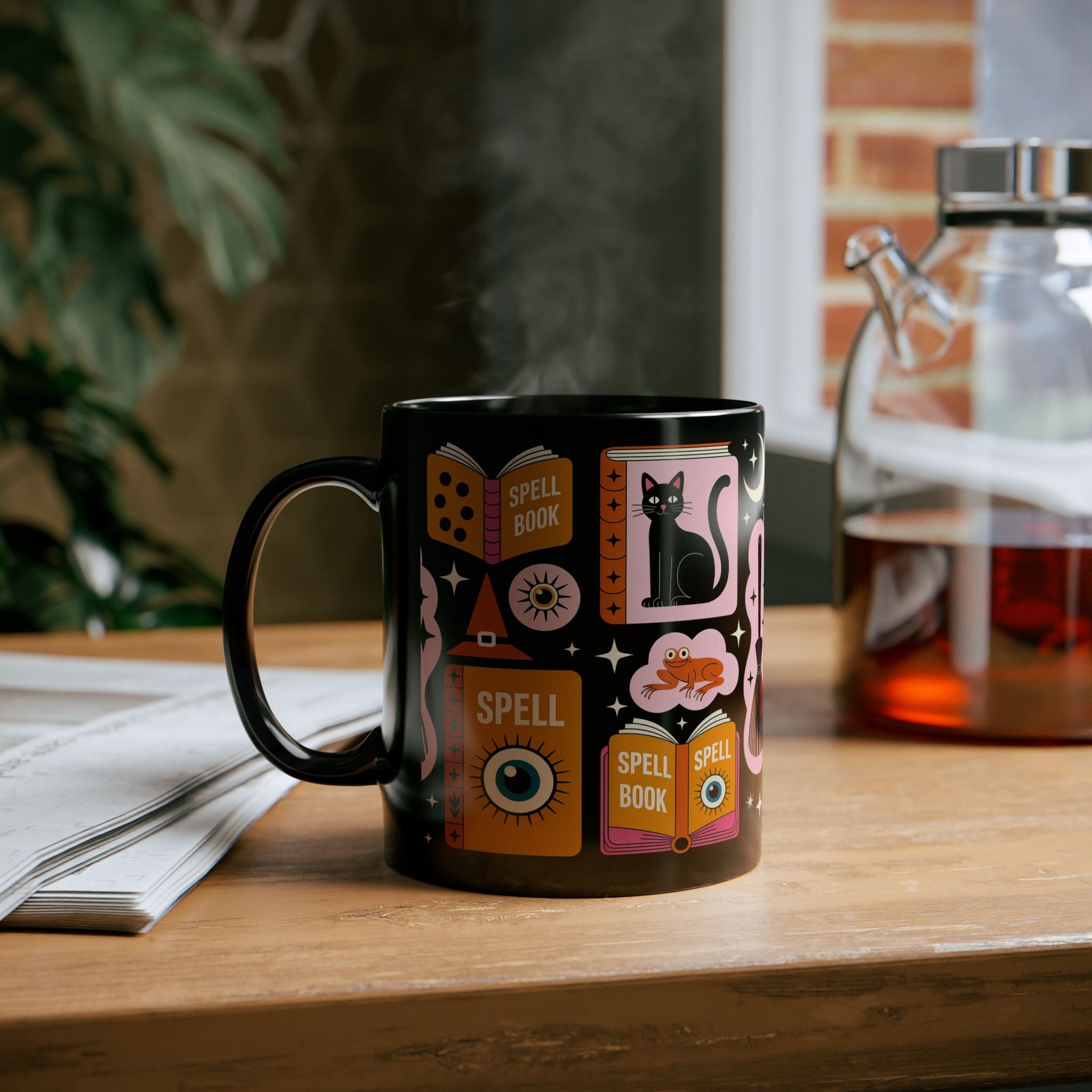 Black mug with colorful spell book Halloween designs on a wooden surface