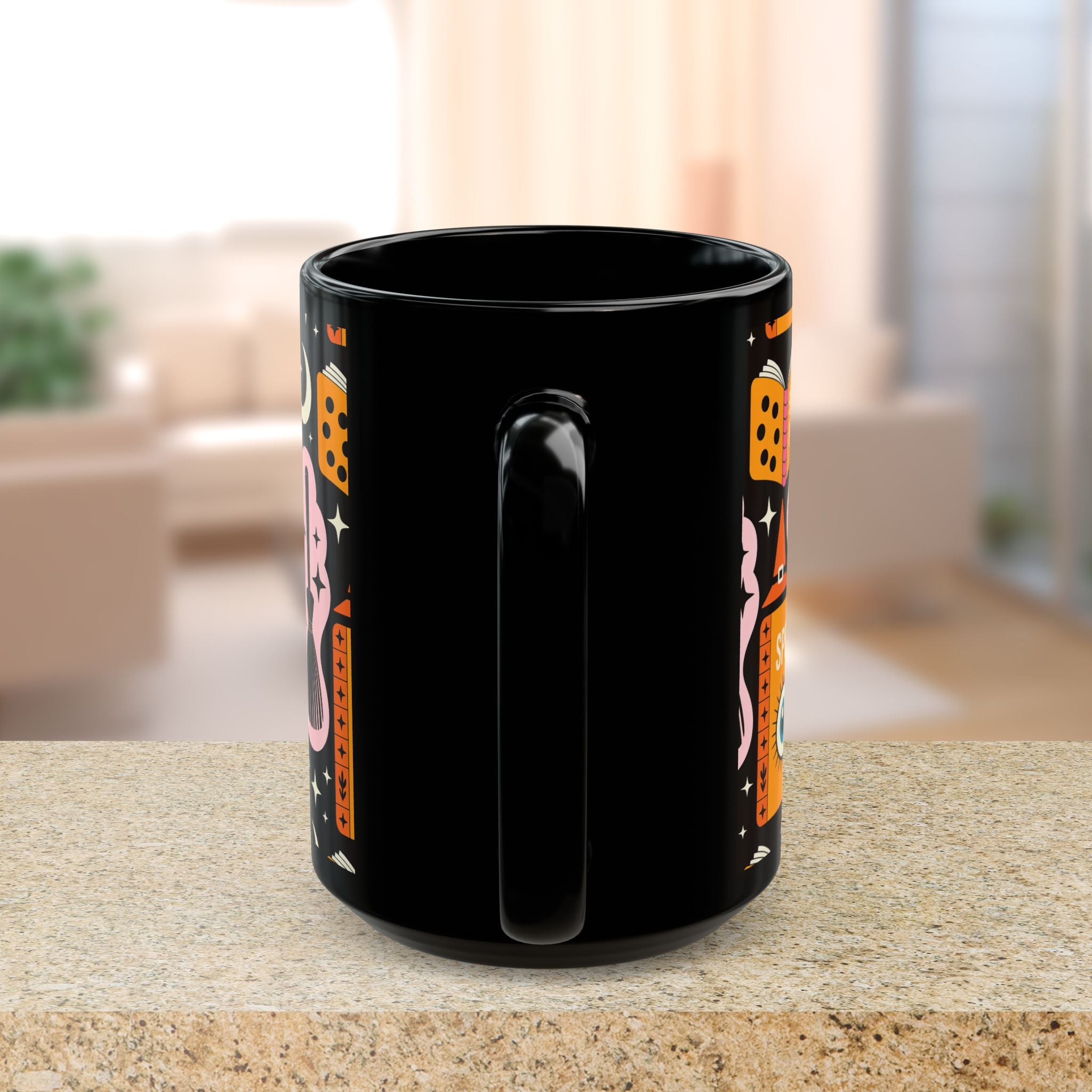 Black mug with colorful designs on a blurred indoor background