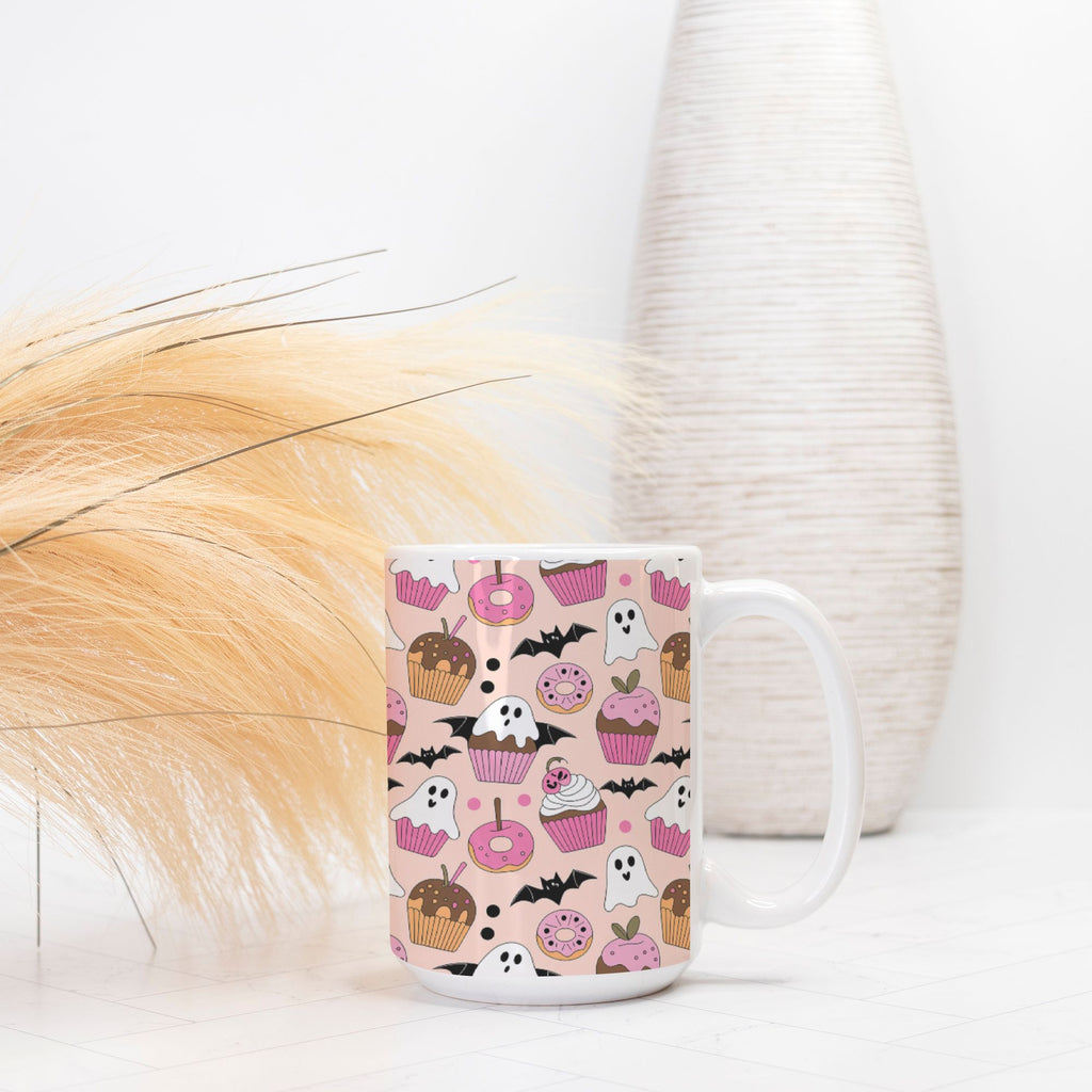 White mug with Halloween-themed pink pattern on a white surface with decorative elements.