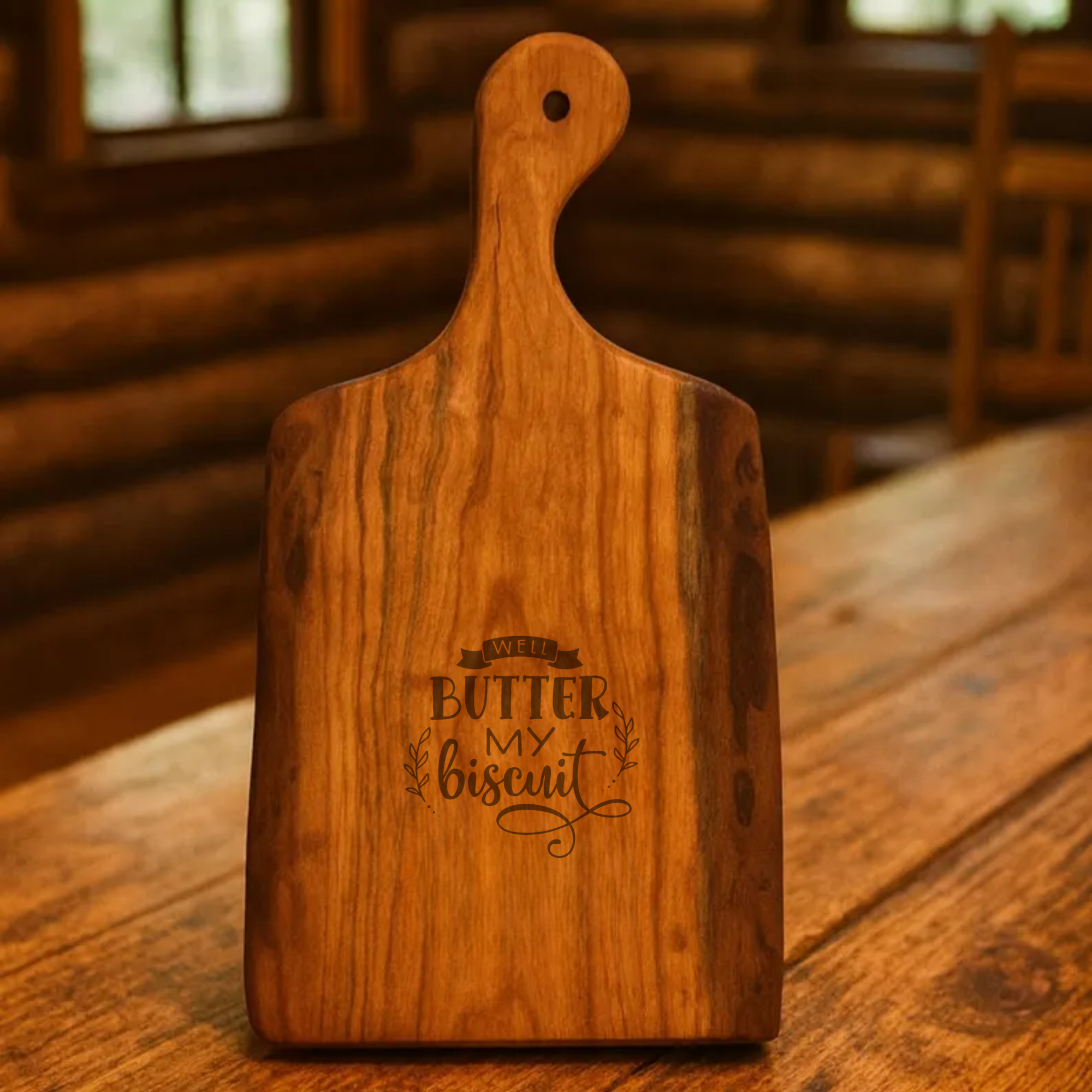 Wooden cutting board with 'Butter My Biscuit' engraving on a wooden table.