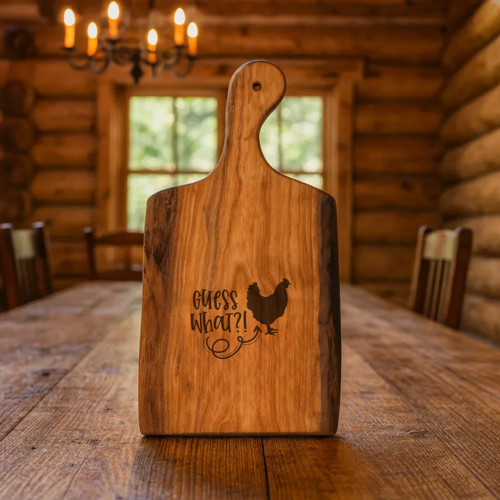 Wooden cutting board with engraved text and chicken silhouette on a wooden table in a log cabin setting.