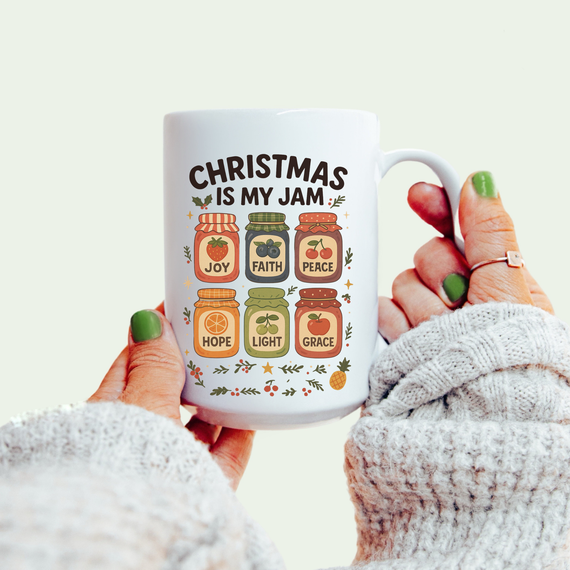 Mug with 'Christmas is my jam' design held by a person wearing a white sweater.
