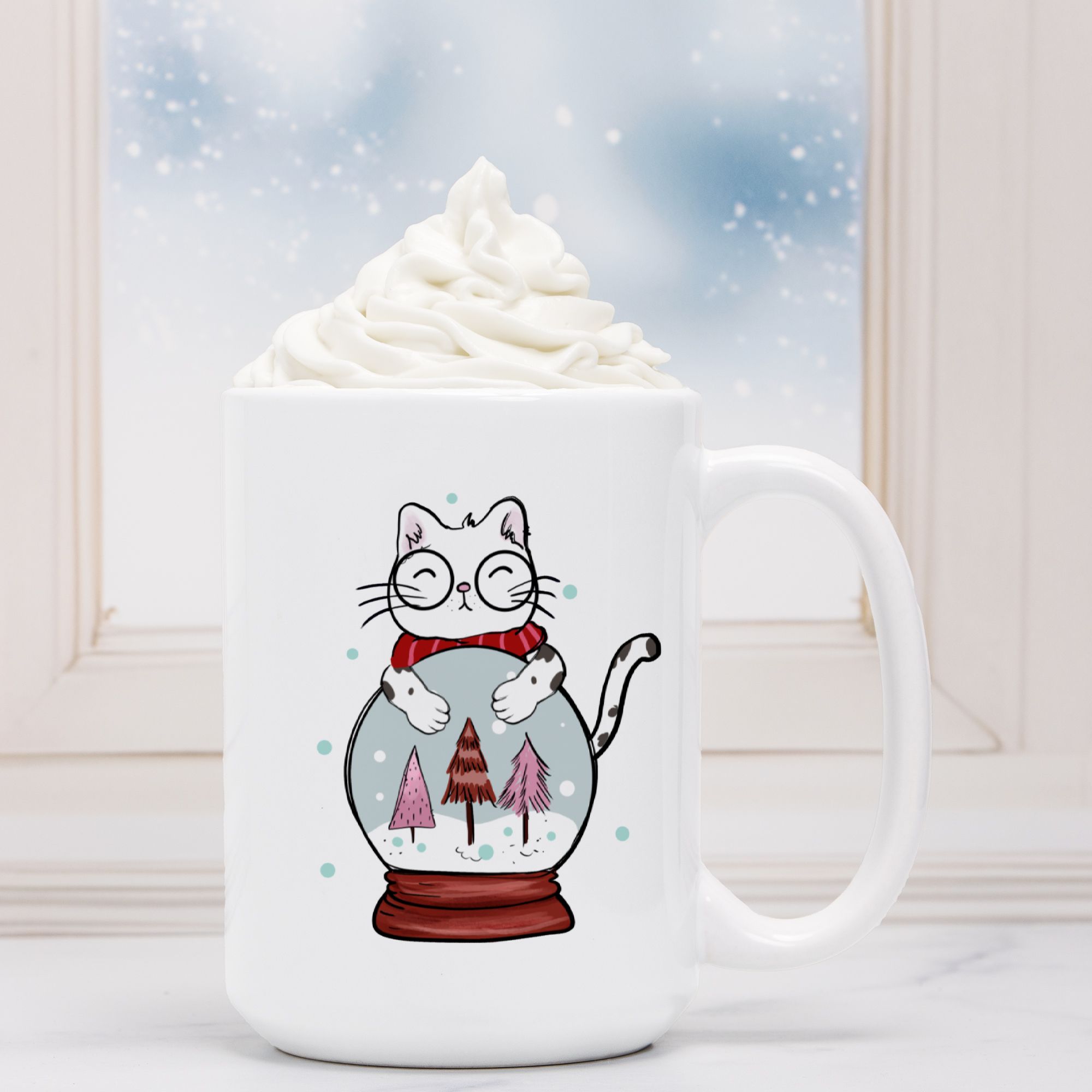 White mug with a cat illustration inside a snow globe, filled with hot chocolate and whipped cream.