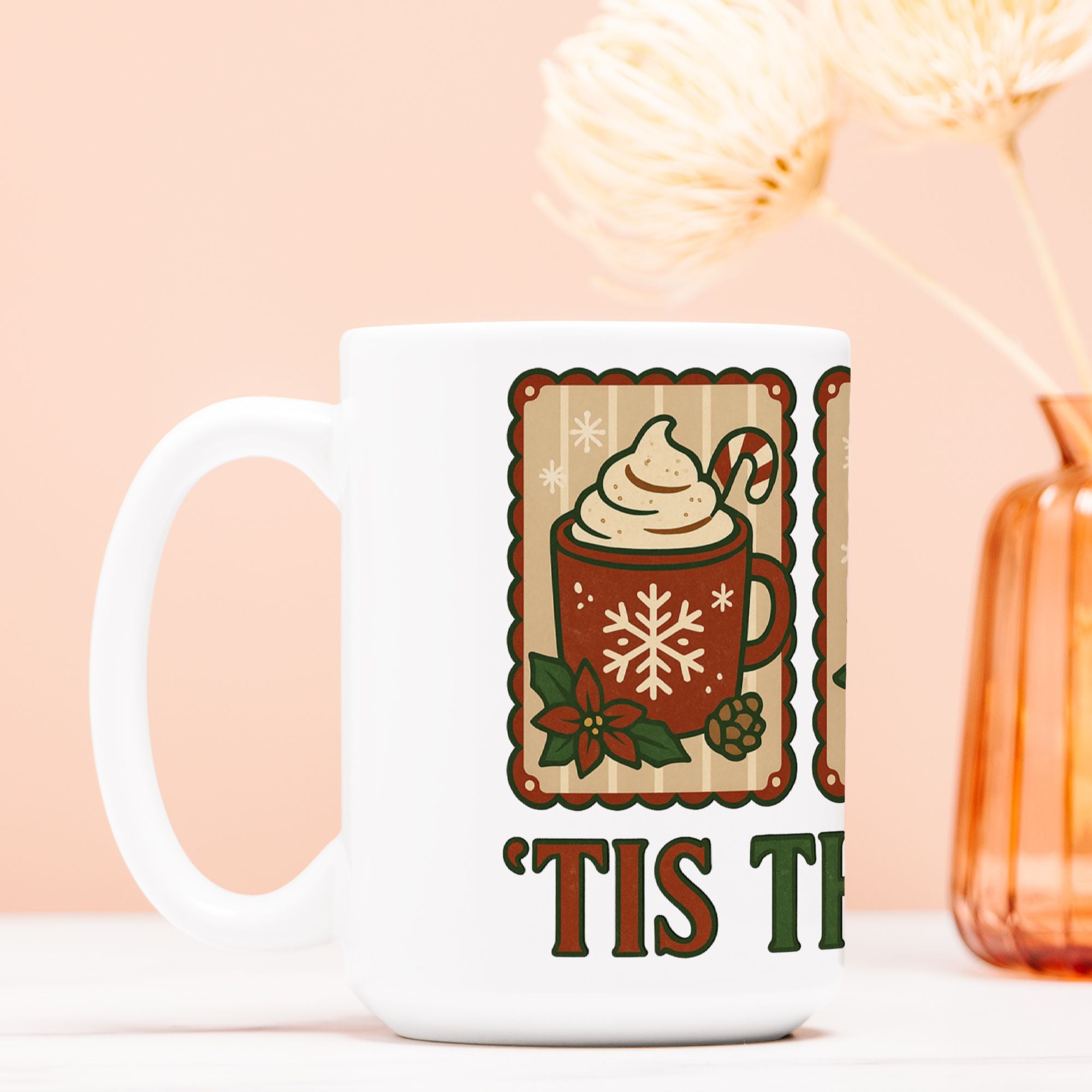 White mug with a festive design featuring a hot chocolate cup and text on a light pink background.