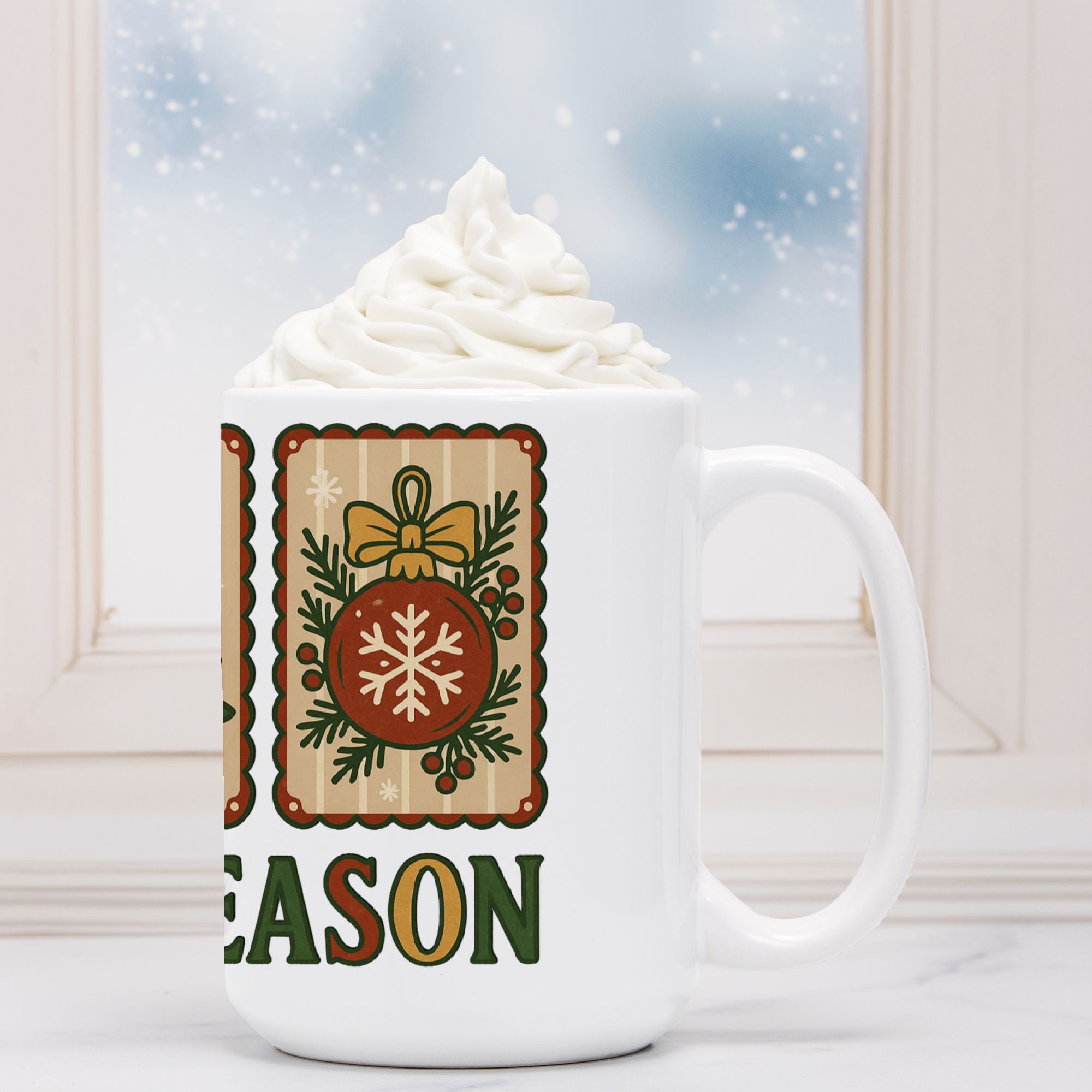 White mug with Christmas-themed design and 'Tis The Seas' text, filled with hot chocolate and whipped cream.n