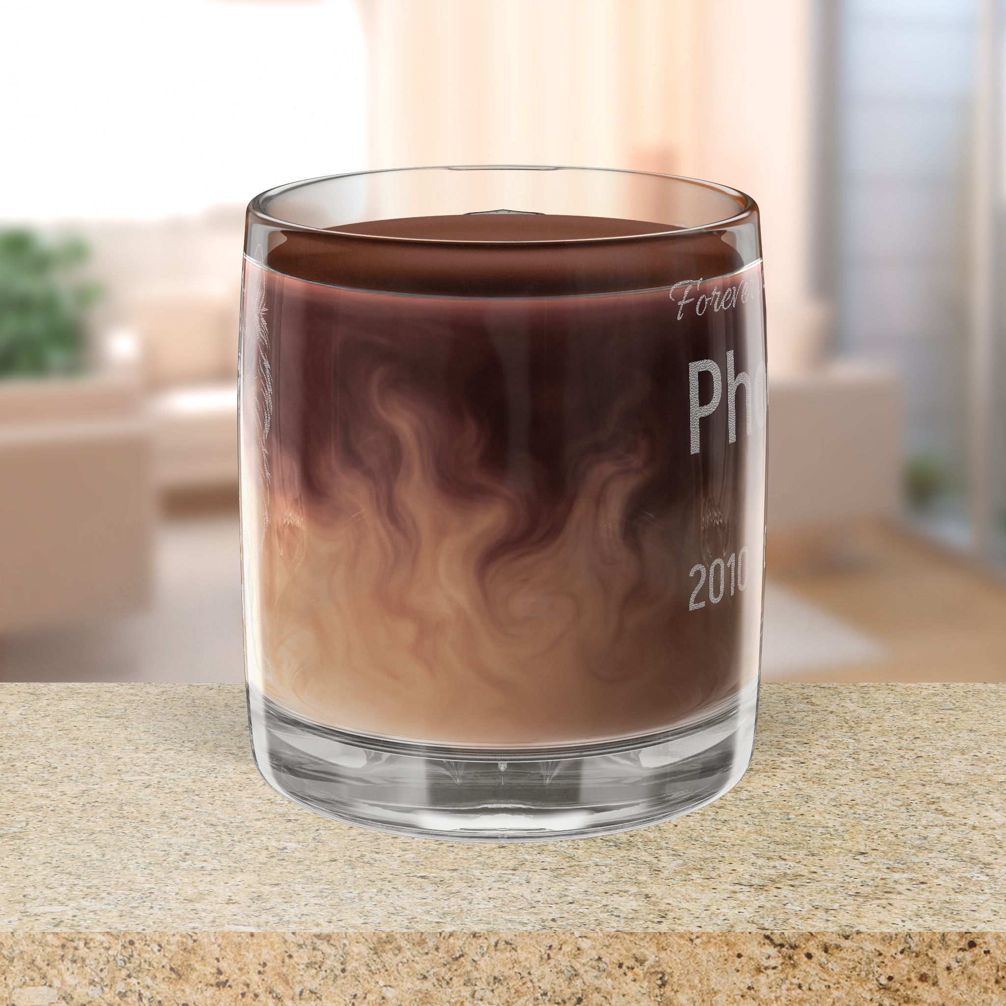 Glass mug with coffee & cream on a countertop, blurred indoor background