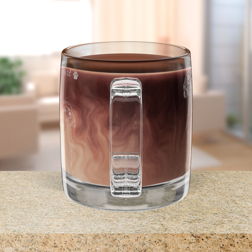 Clear glass mug with handle filled with hot chocolate on a blurred background
