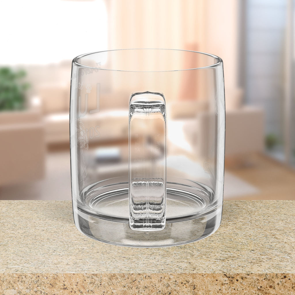 Clear glass mug with handle on a blurred indoor background