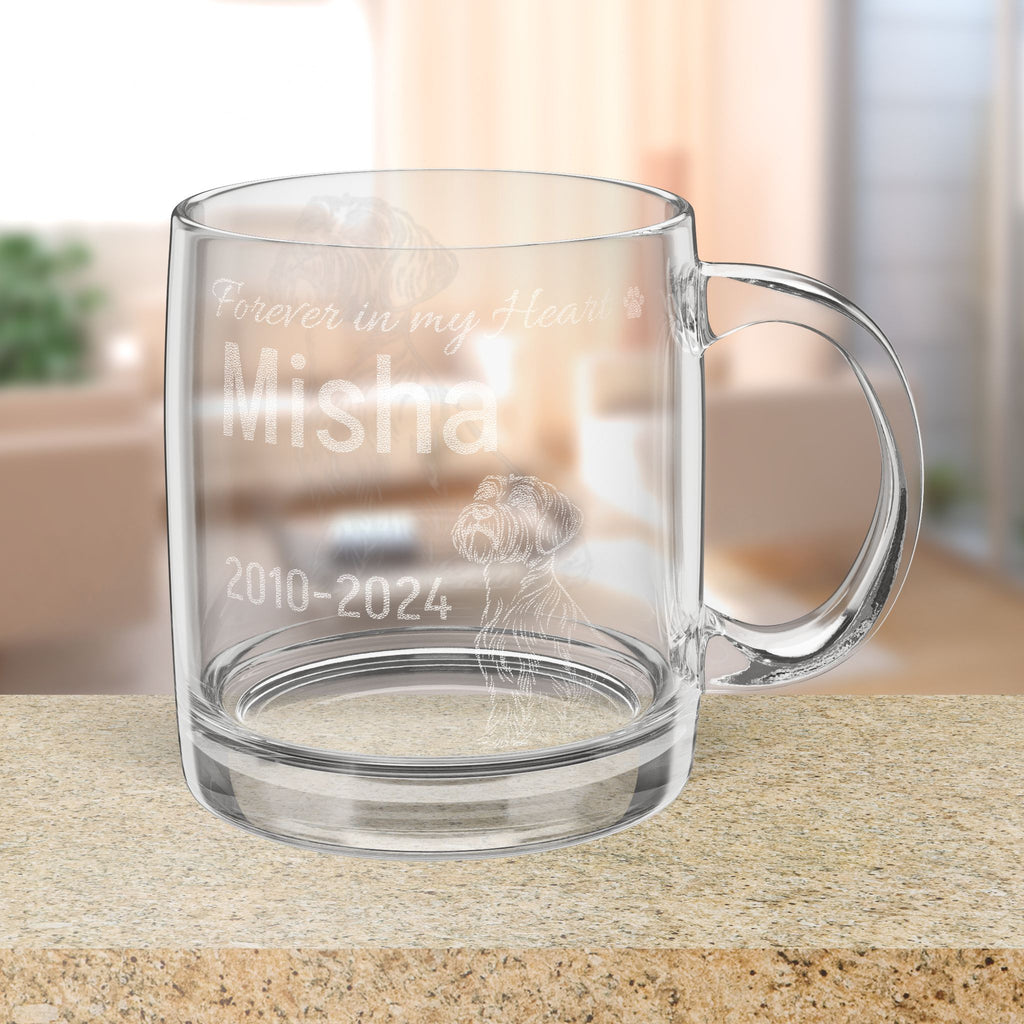 Clear glass mug with engraved memorial text on a blurred background