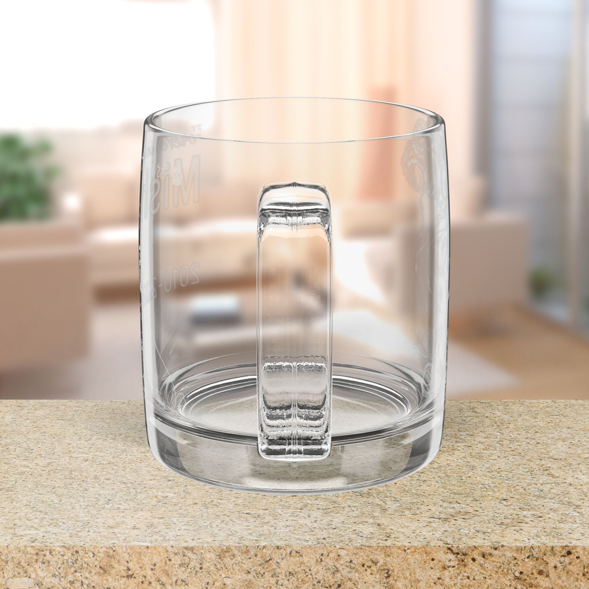 Clear glass mug with handle on a blurred indoor background