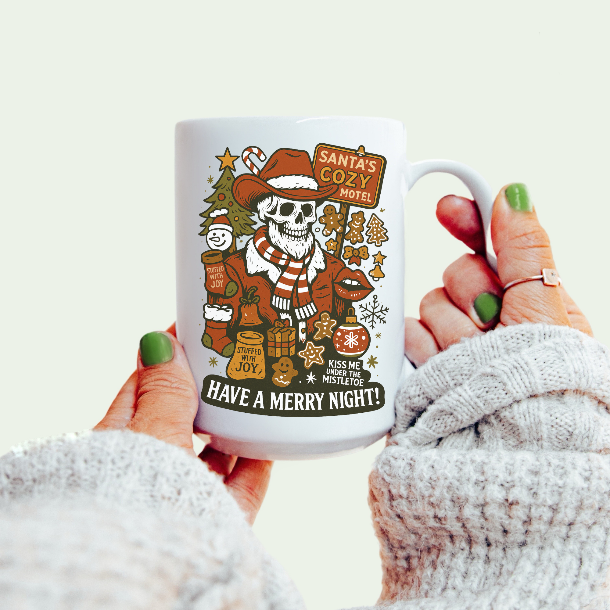 Mug with a festive design featuring a skeleton in a Santa hat, held by a person wearing a white sweater.