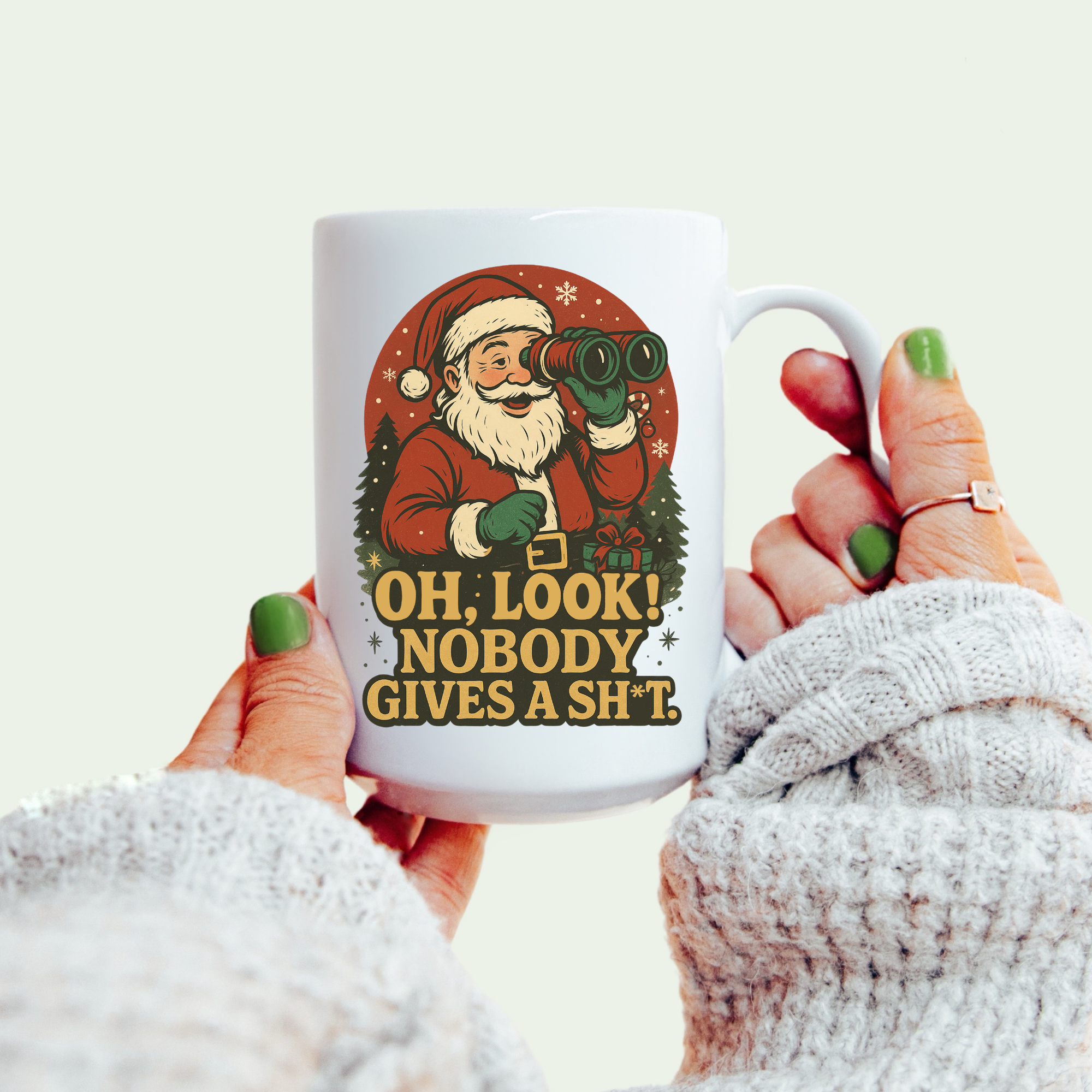 Mug with Santa Claus design and text held by a person wearing a white sweater.