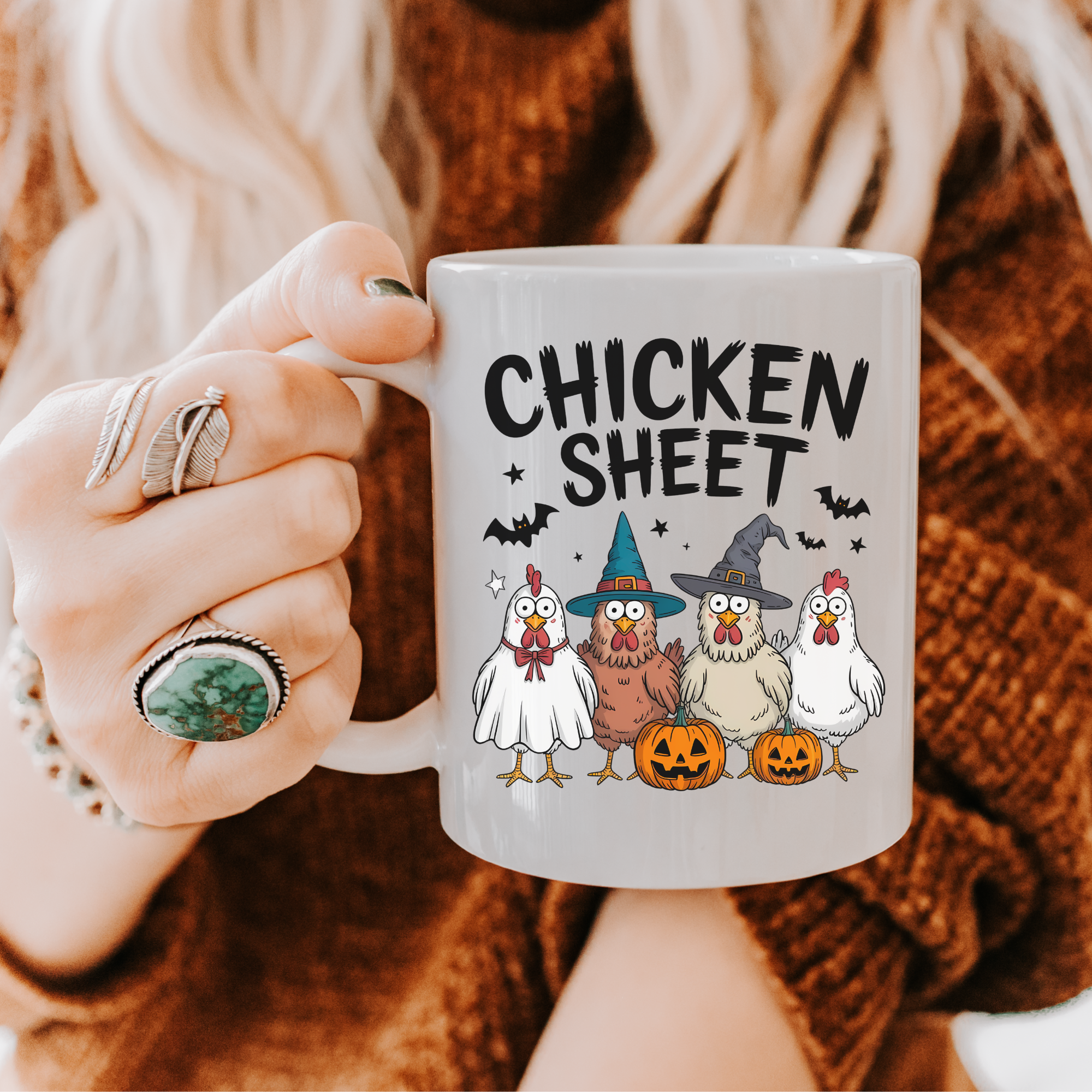 Person holding a mug with Halloween-themed design featuring chickens in costumes and the text 'Chicken Sheet'.