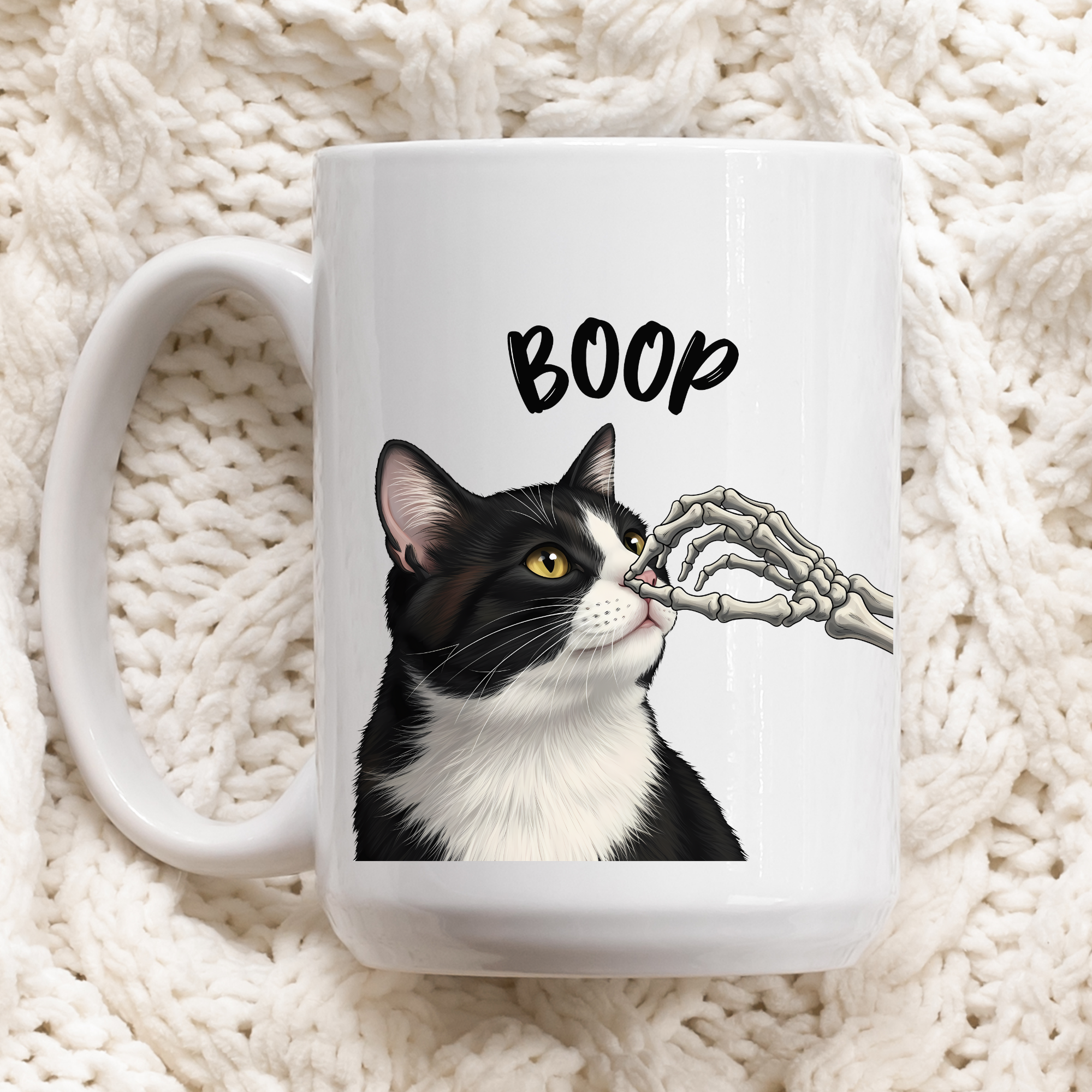 Mug with a cat illustration and 'BOOP' text on a textured white surface