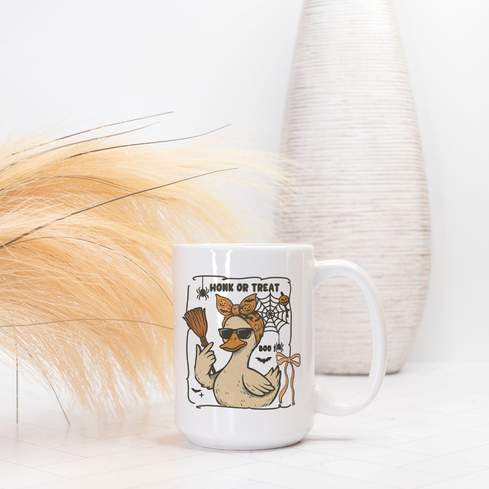 White mug with a Halloween-themed duck design on a white surface with decorative elements.