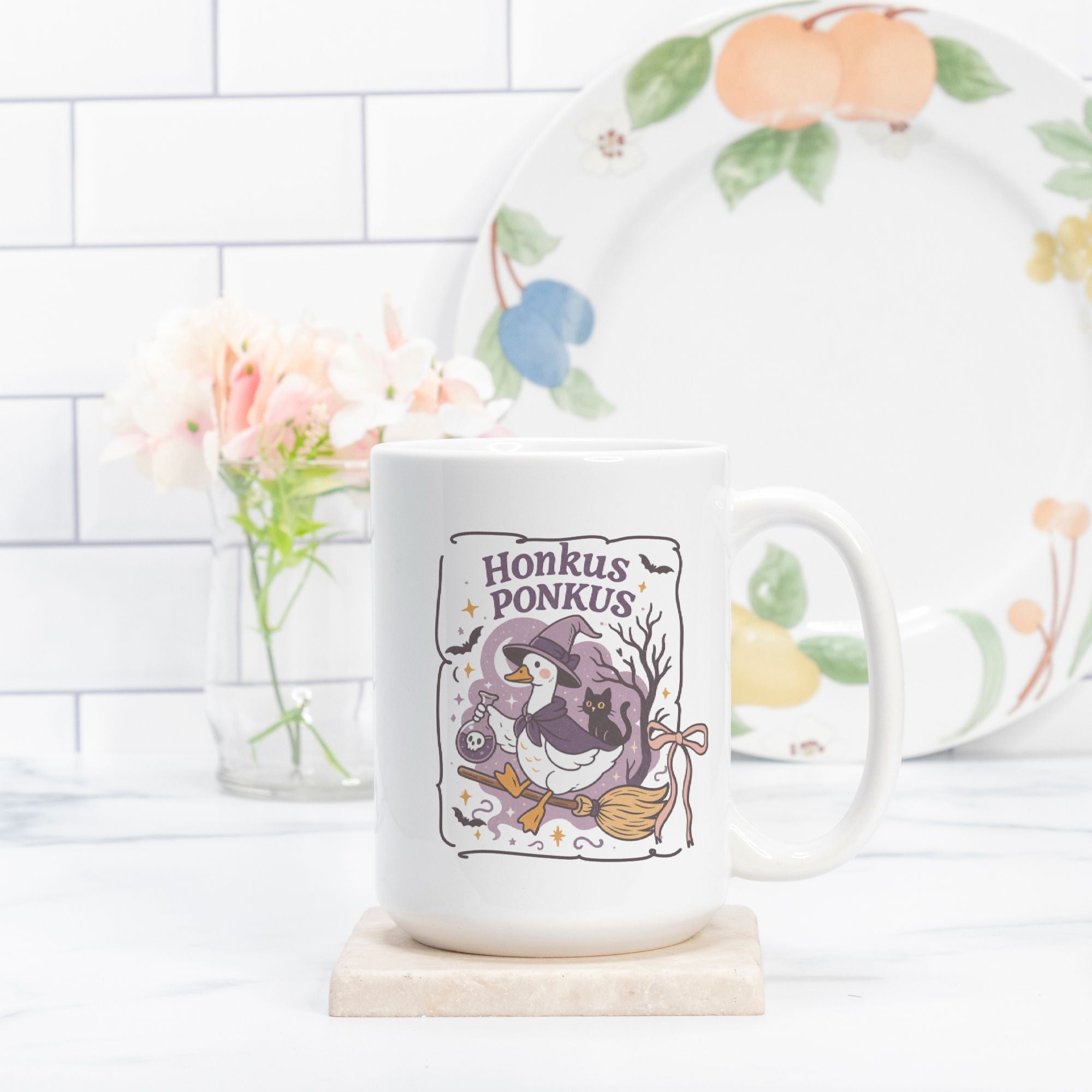 Mug with 'Honkus Ponkus' design on a white surface with a decorative plate in the background.