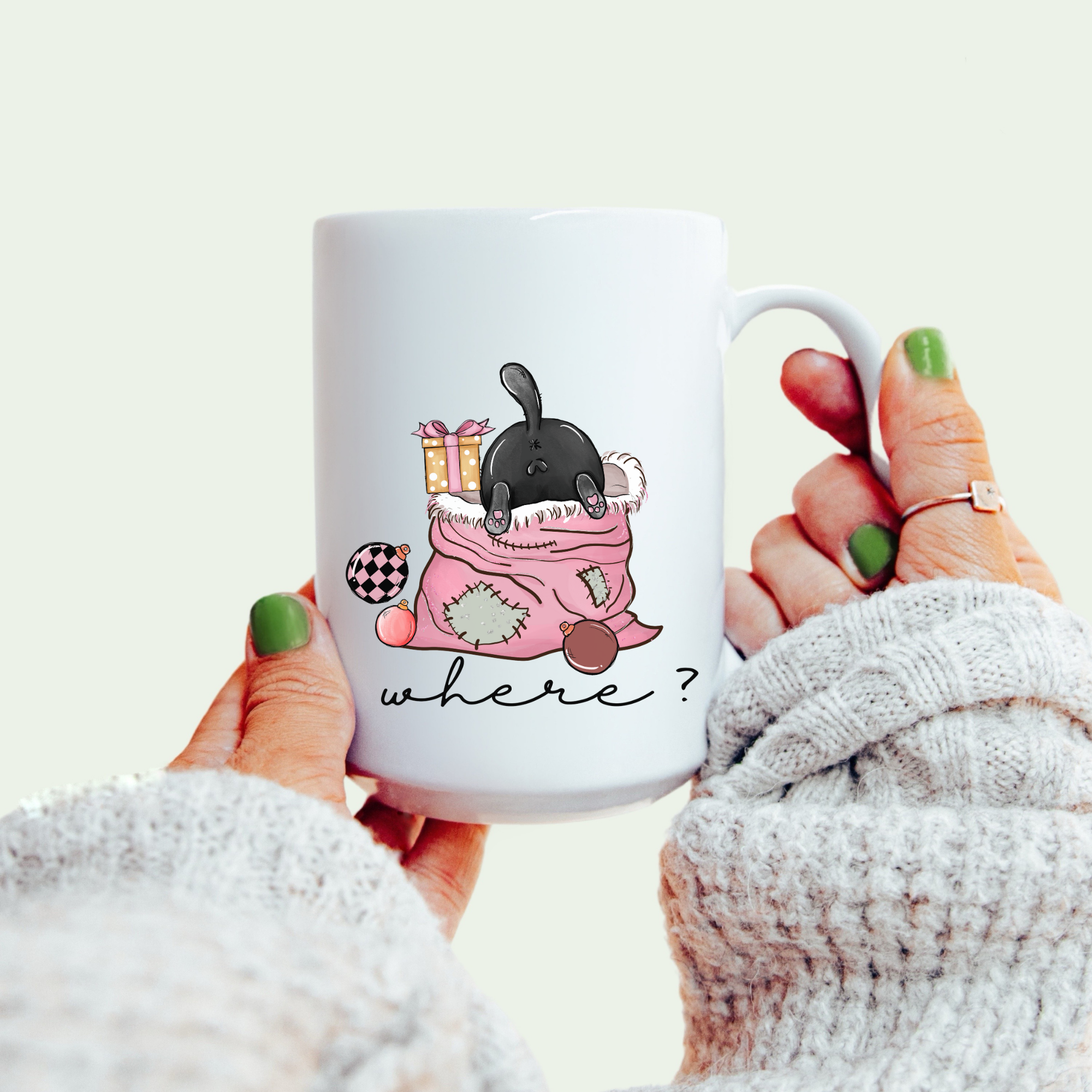 White mug with a black cat illustration and 'WHAT?' text, held by a person.
