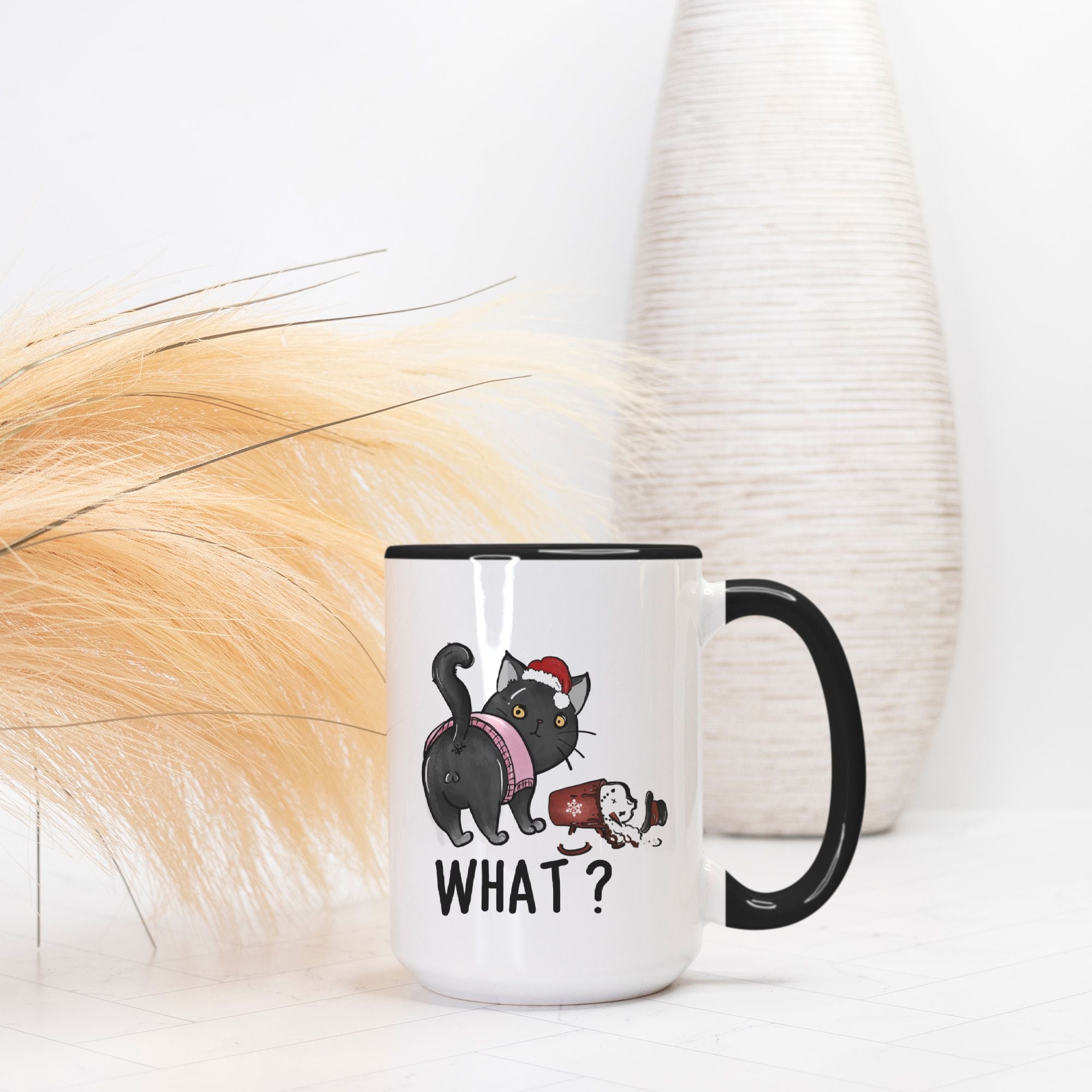 Mug with a hand drawn Christmas black cat graphic and 'WHAT?' text on a white surface with decorative elements.