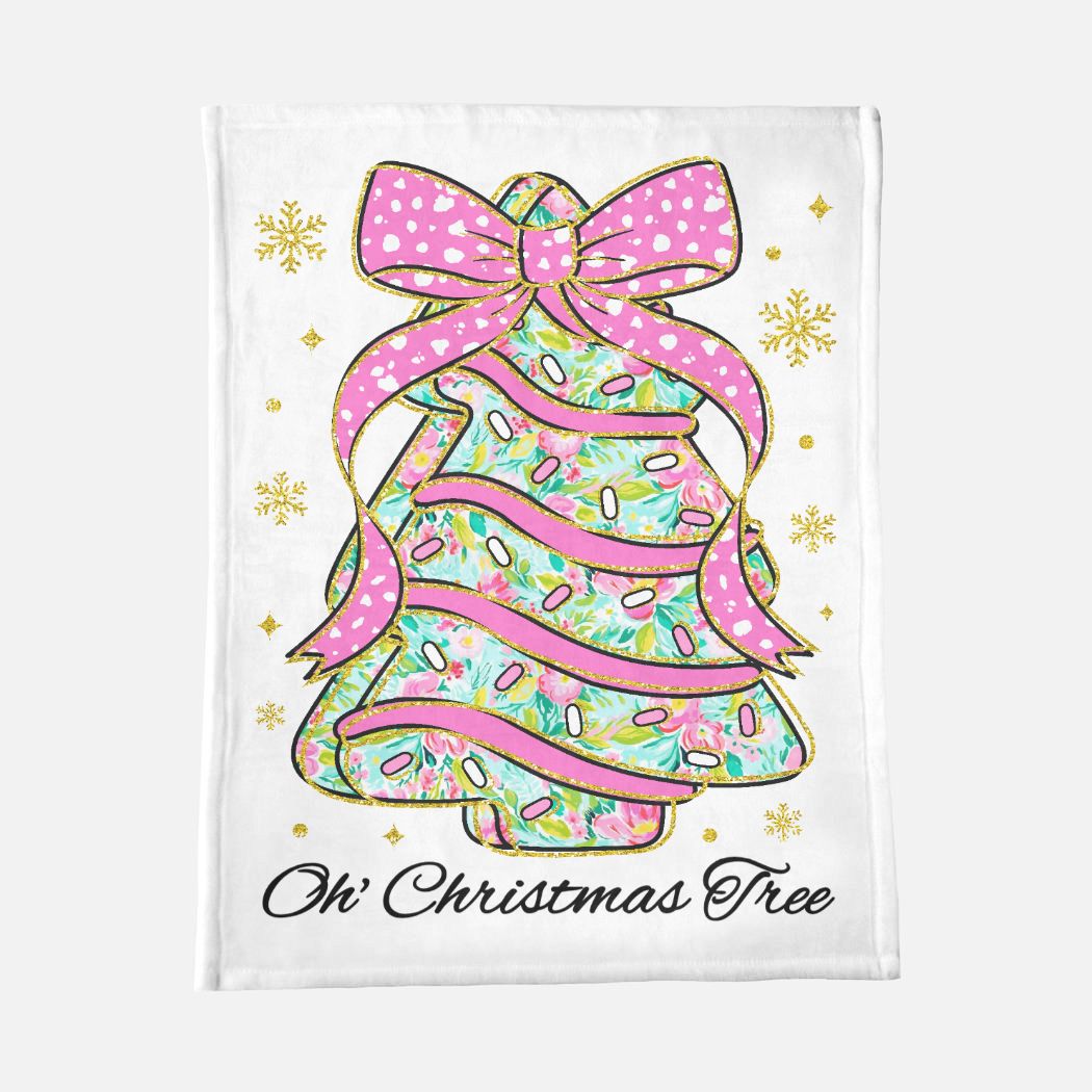 Decorative blanket with a Christmas tree design featuring a pink bow and sprinkles on a white background.