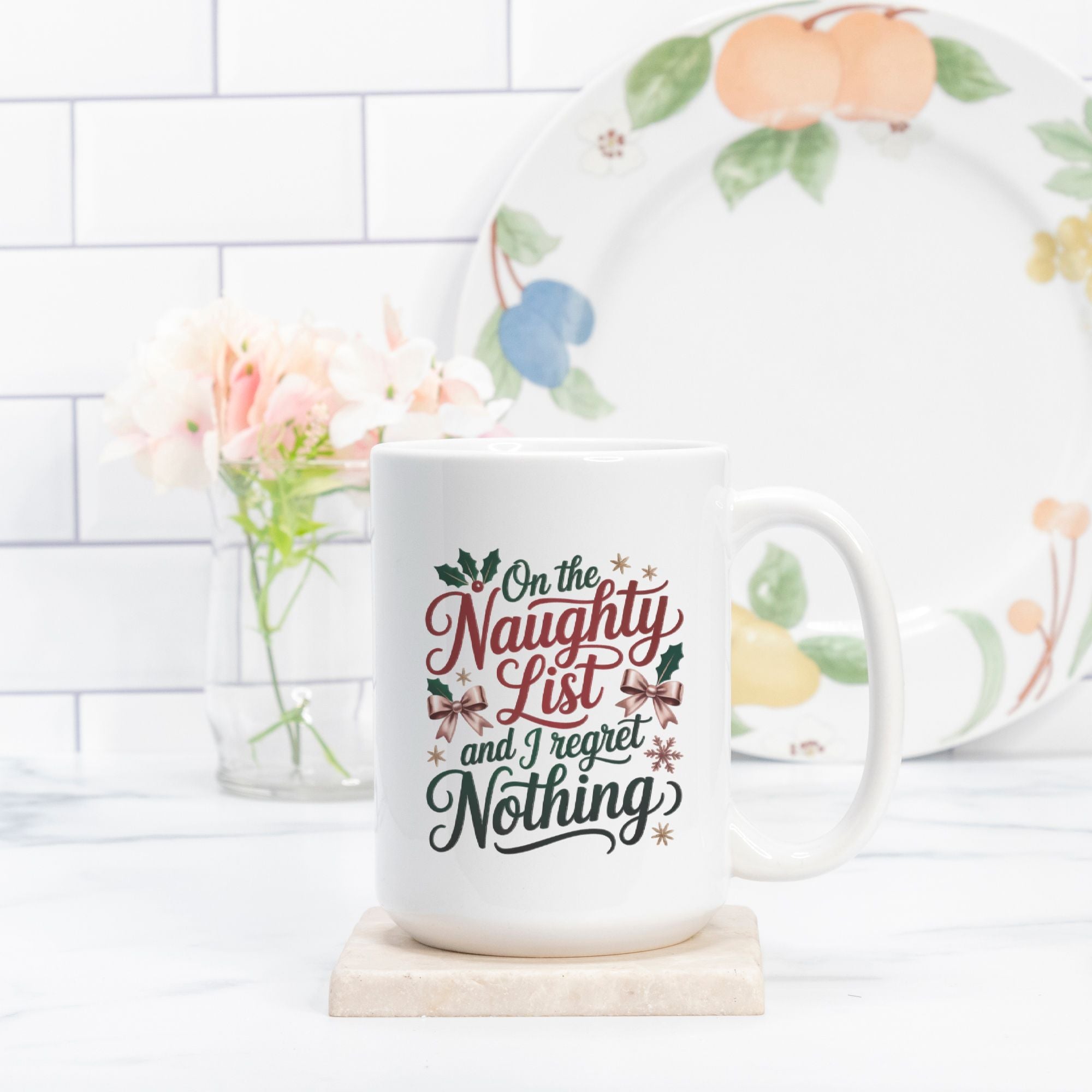 Mug with text 'On the Naughty List and I regret Nothing' on a white surface with a decorative plate in the background.