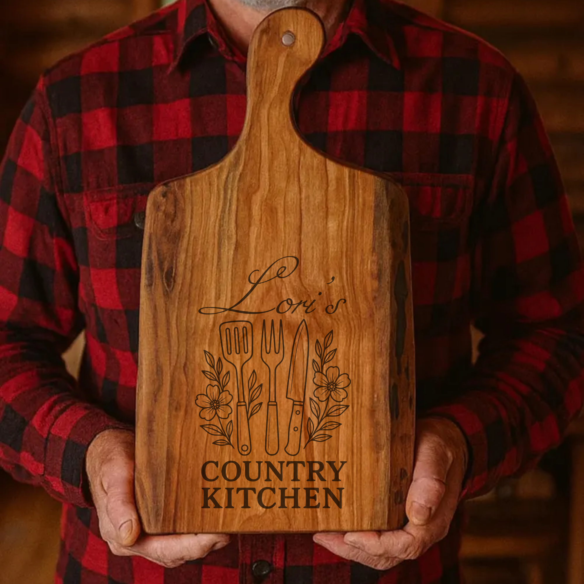 Person holding a wooden cutting board with 'Le Lori's Country Kitchen' engraving.