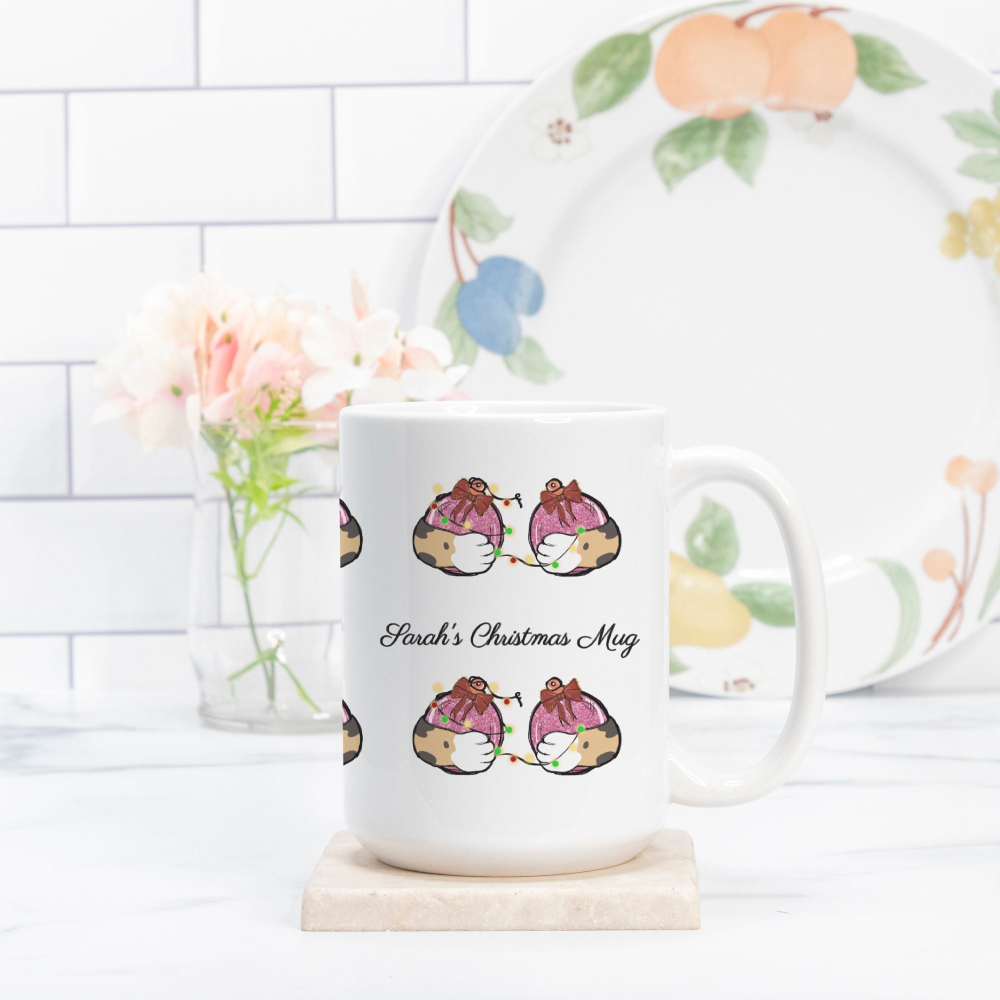 White mug with decorative design and text, placed on a white surface with a floral plate in the background.