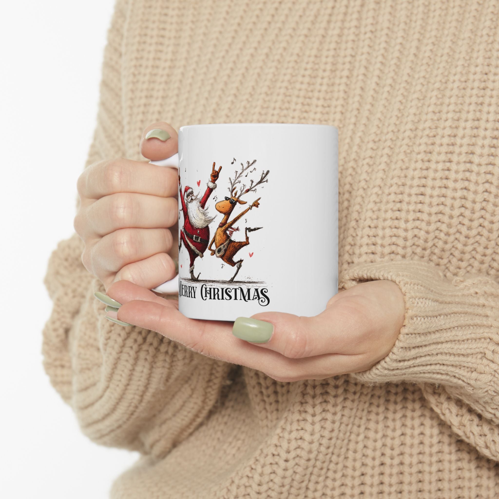 Person holding a white mug with Christmas design, wearing a beige sweater.