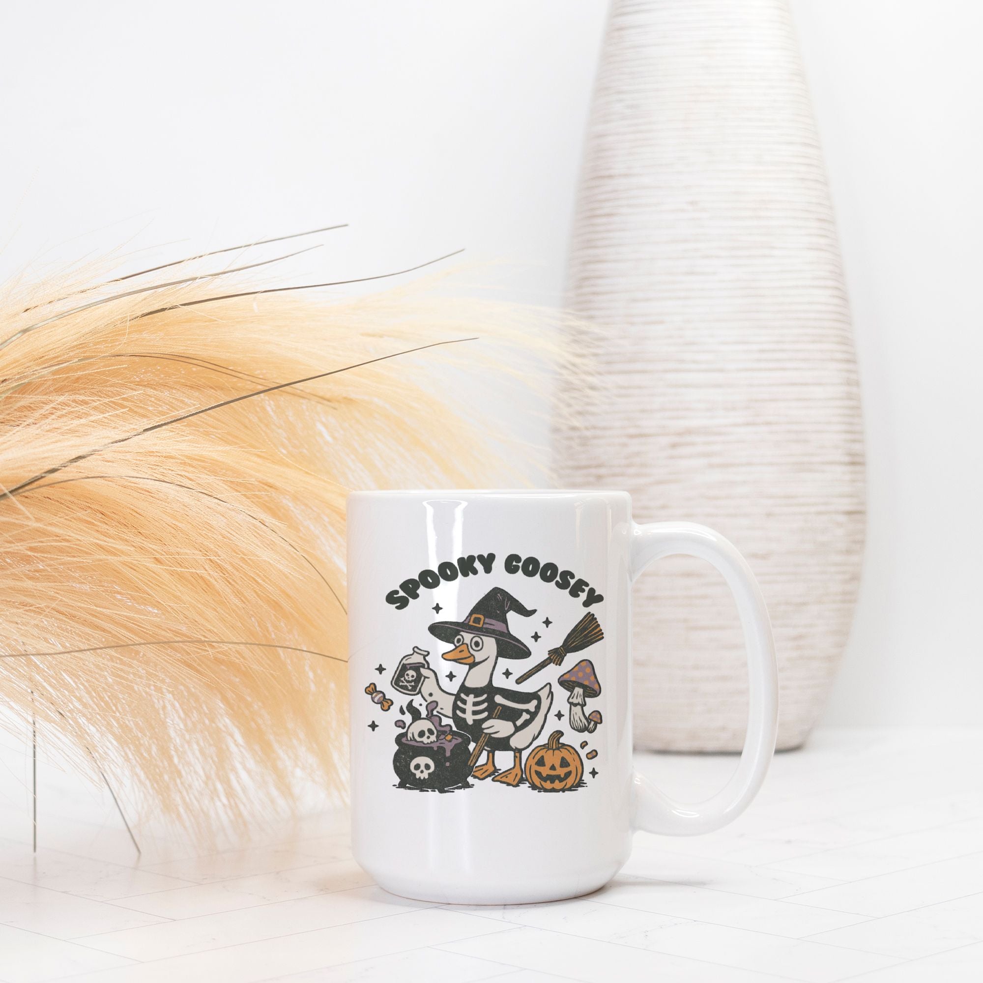 White mug with Halloween-themed design featuring a skeleton goose, pumpkins, and text on a white background.