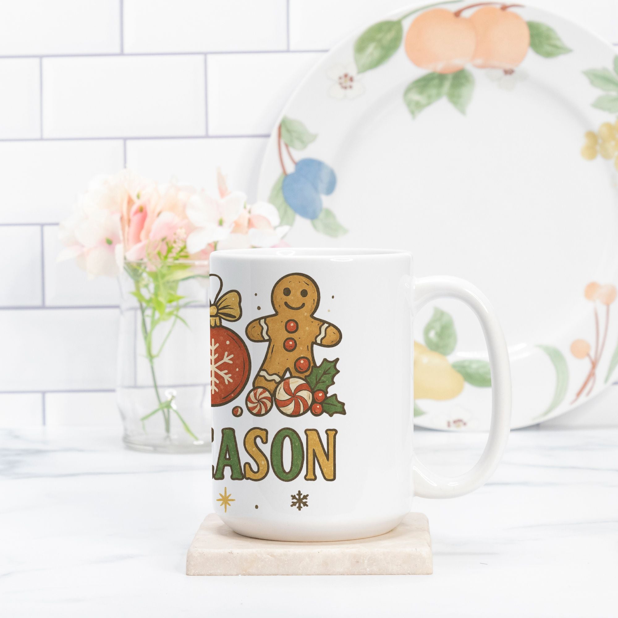 Mug with gingerbread design and 'Mason' text on a white surface with a decorative plate in the background.