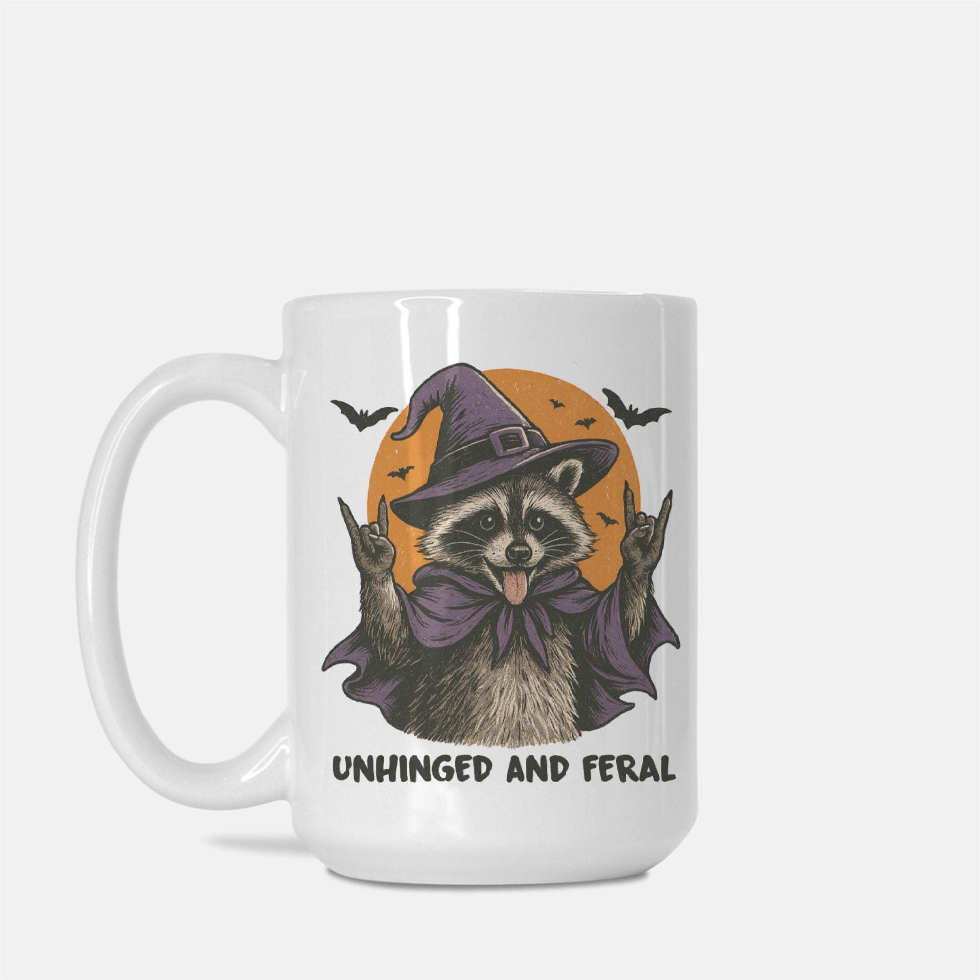 Mug with a raccoon wearing a witch hat and cape design, labeled 'Unhinged and Feral', on a white background.