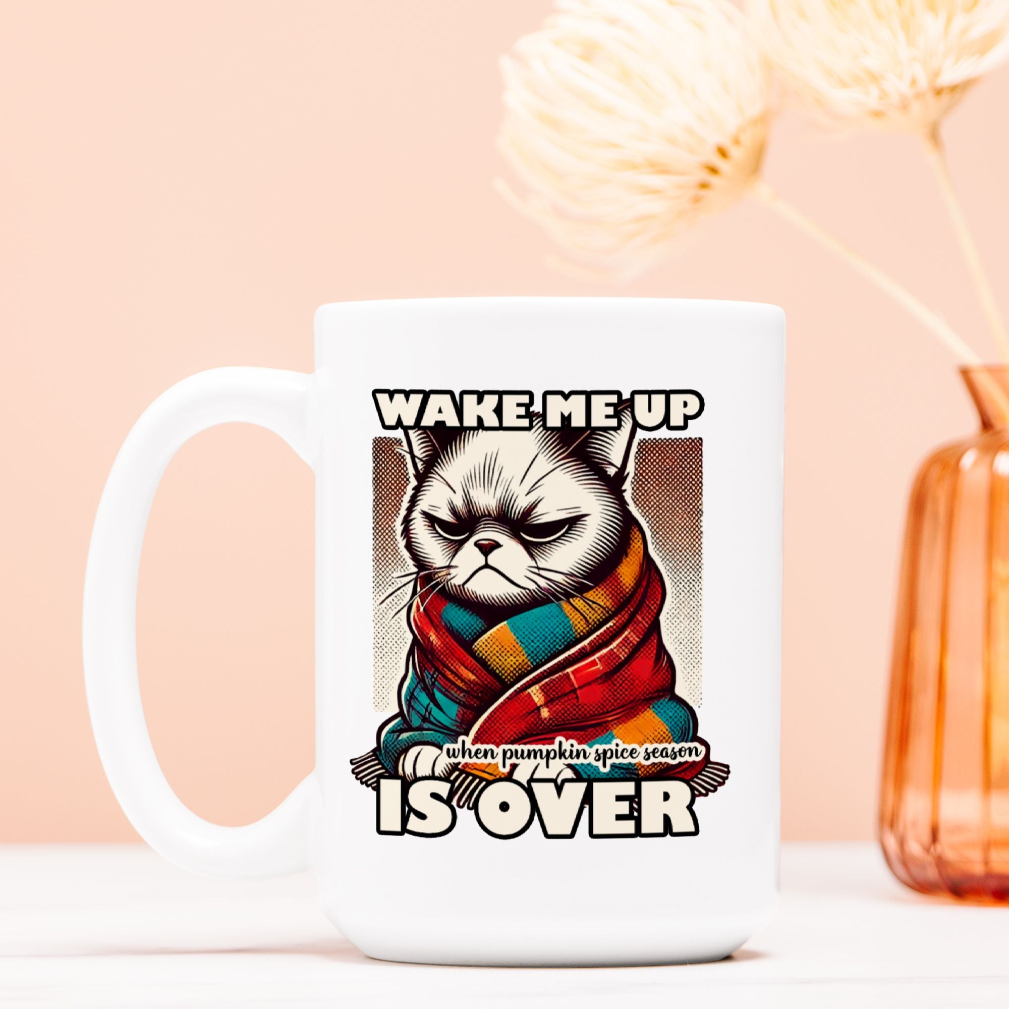 White mug with a cat in a scarf design and text on a peach background