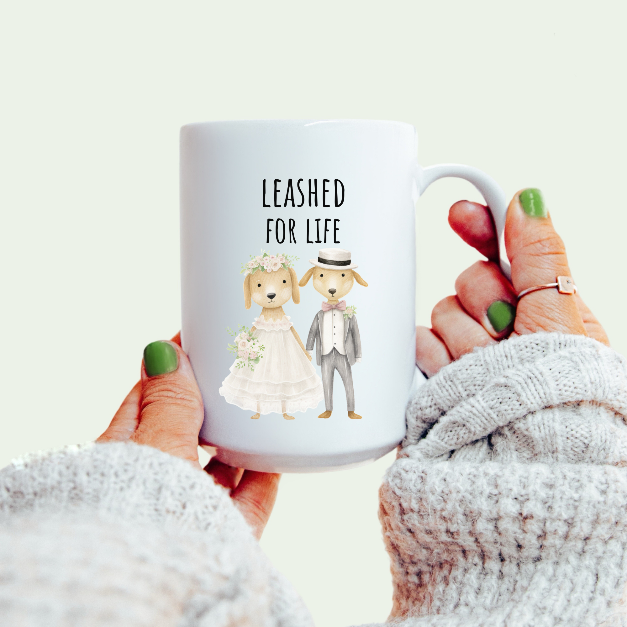 Mug with 'Leashed for Life' text and dog illustrations held by a person.