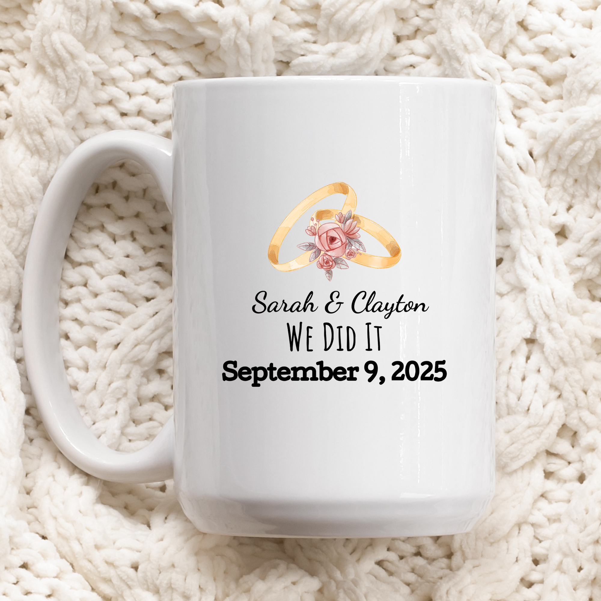 White mug with wedding rings design and personalized text on a white textured background