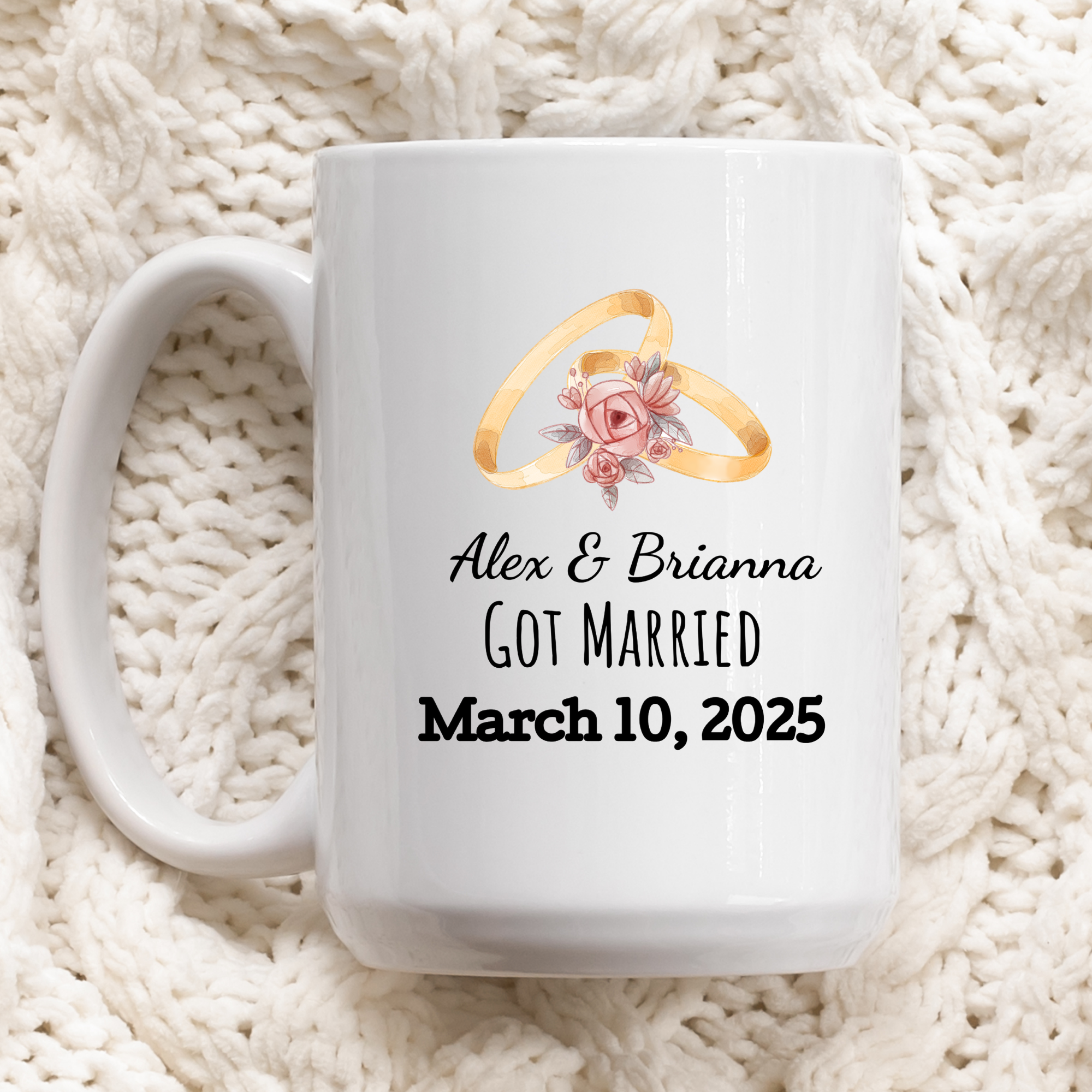 White mug with wedding rings and personalized text on a white textured background