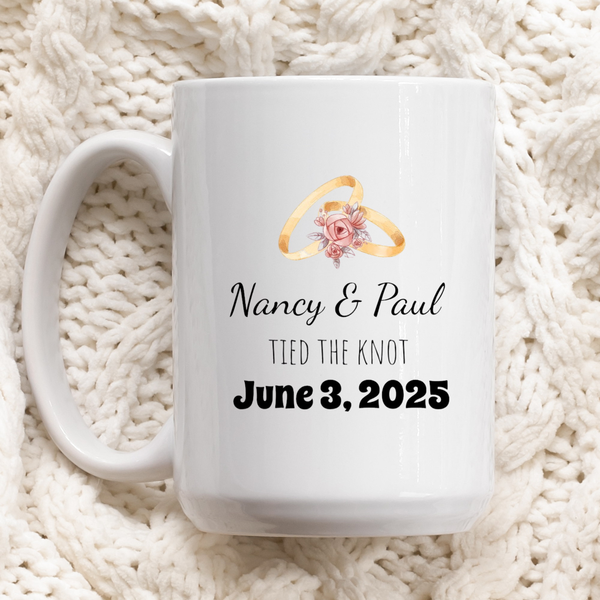White mug with personalized design of wedding rings and text on a white textured background