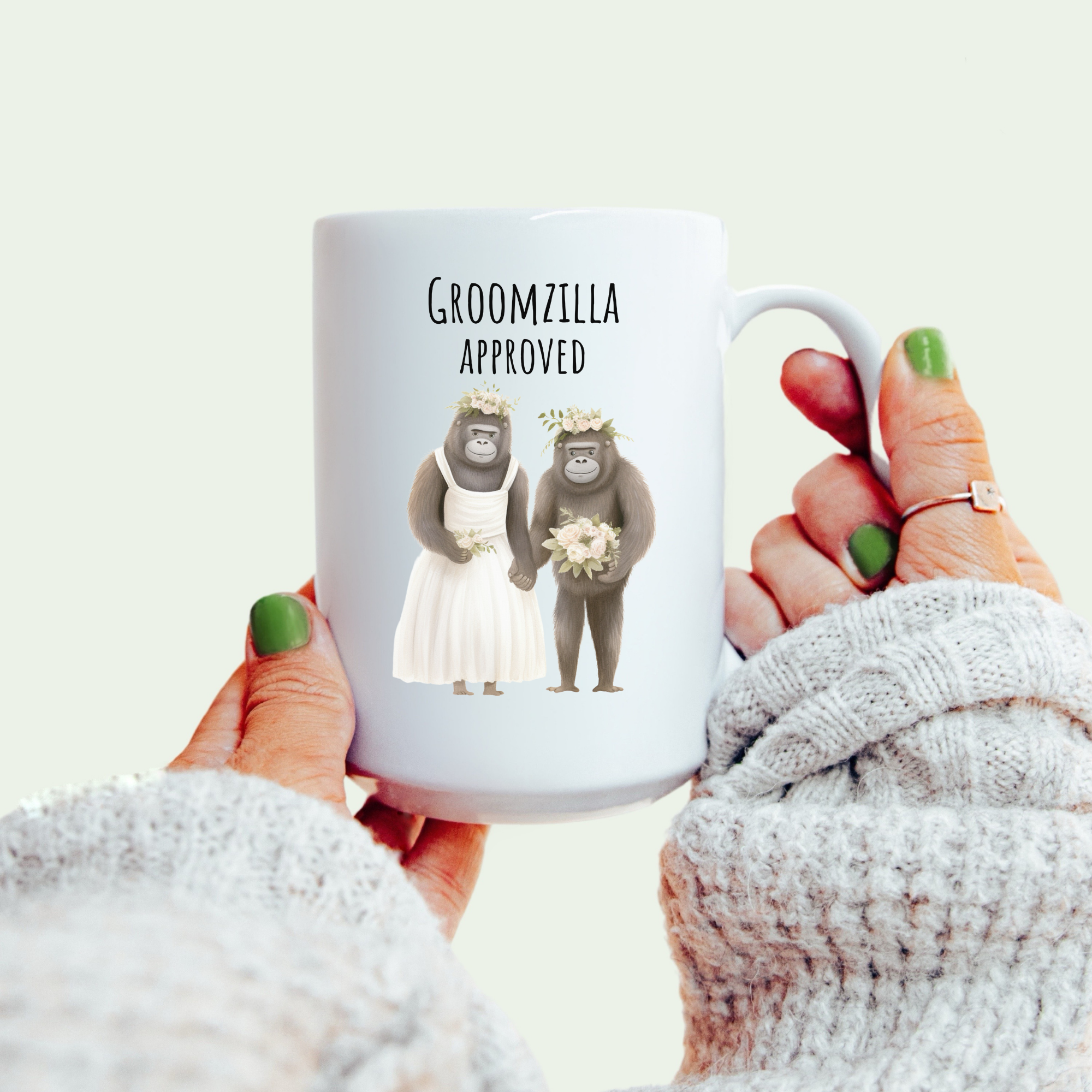 Mug with 'Groomzilla Approved' text and wedding-themed graphics held by a person.