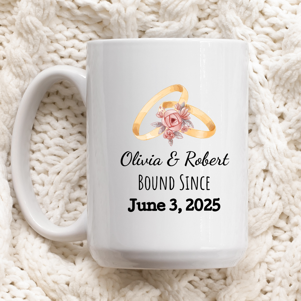 White mug with wedding rings design and personalized text on a white textured background