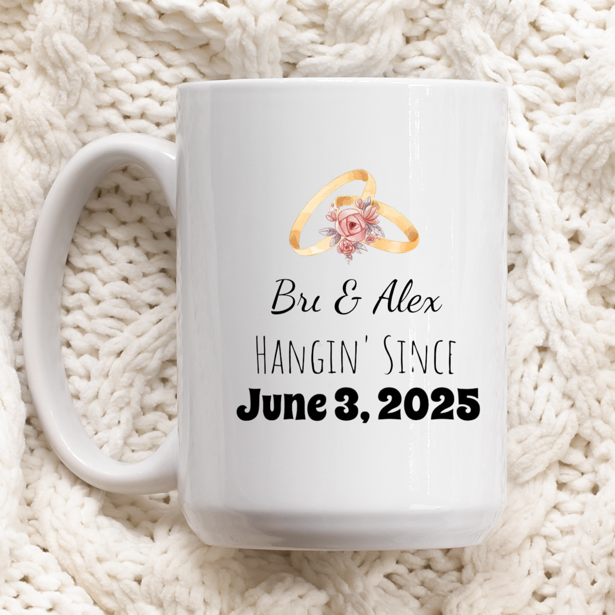 White mug with wedding rings and text 'Bru & Alex HANGIN' Since June 3, 2025' on a white textured background