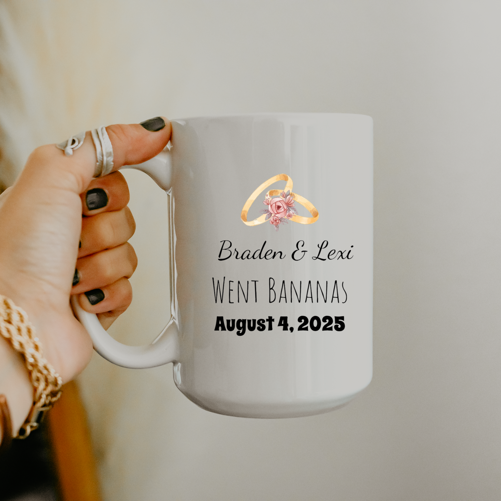 White mug with personalized text and ring design held by a hand.