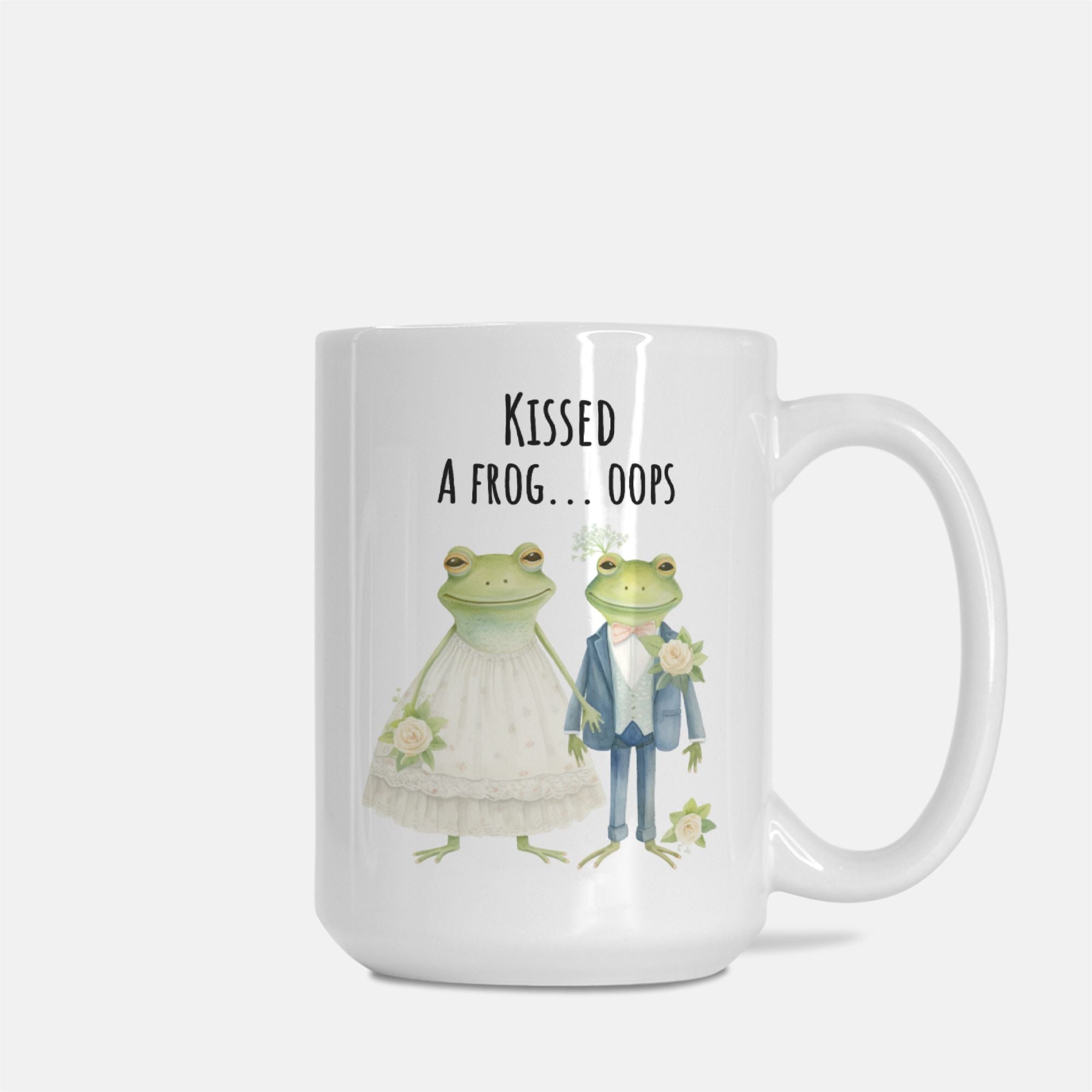Mug with frogs in wedding attire and text 'Kissed a frog... oops' on a white background