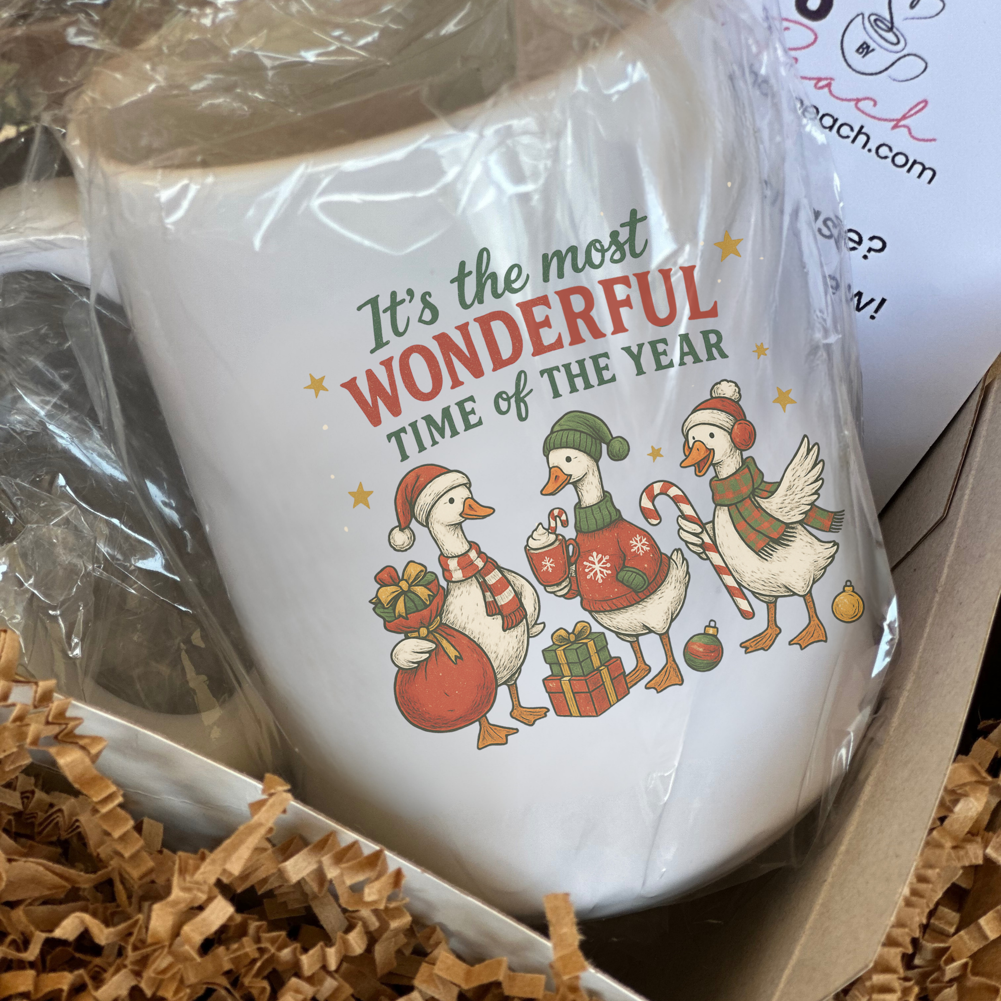 White mug with Christmas design and text 'It's the most Wonderful time of the year' in a box with brown tissue paper.
